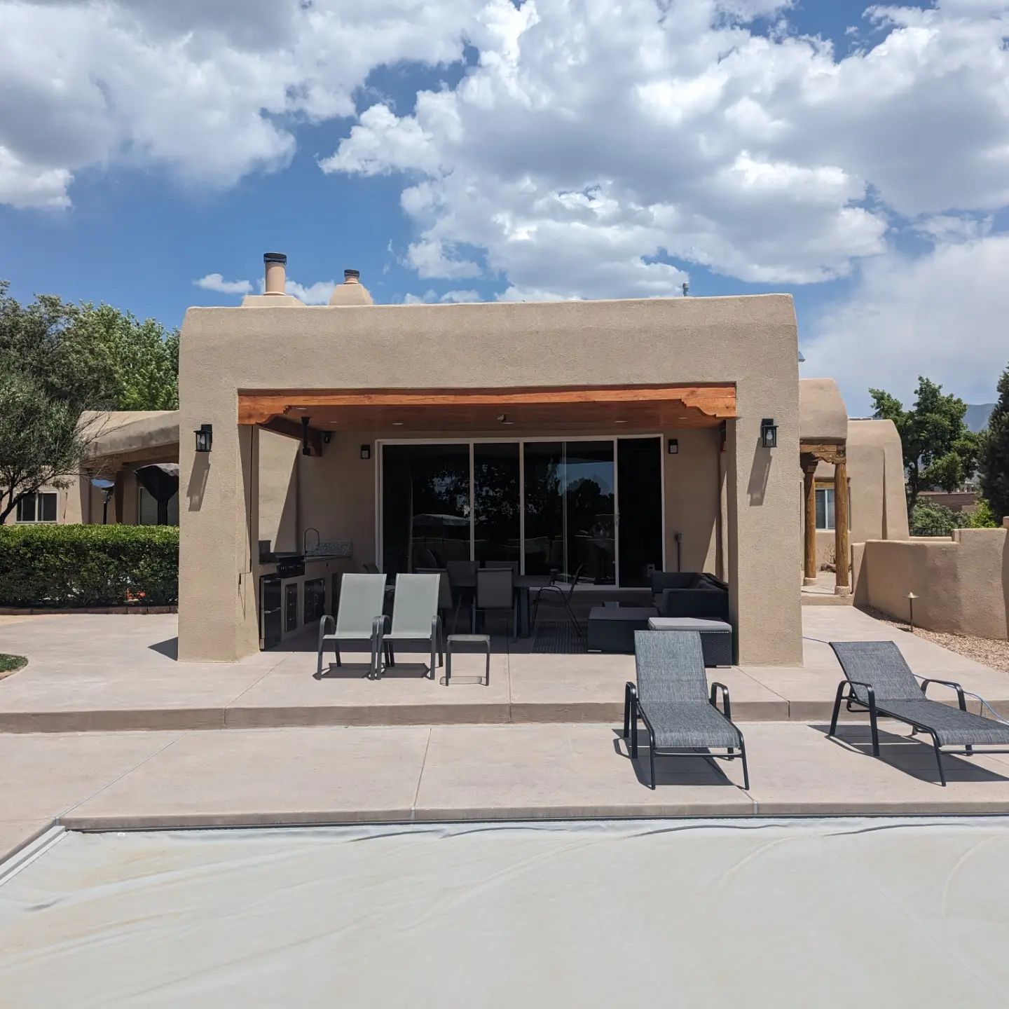 A house with a pool and chairs in front of it