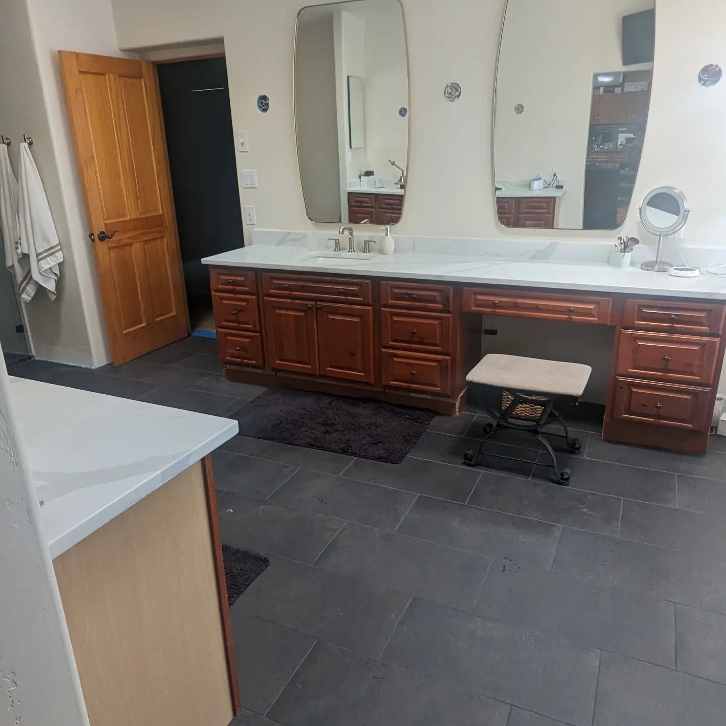 A bathroom with two sinks a mirror and a stool