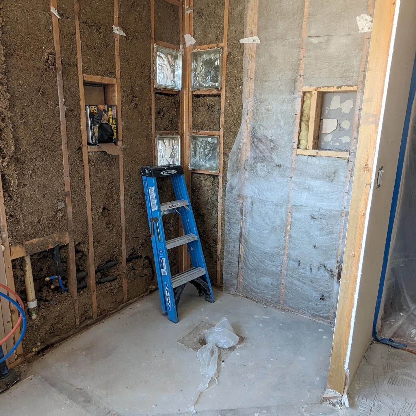 A blue ladder is leaning against a wall in a room