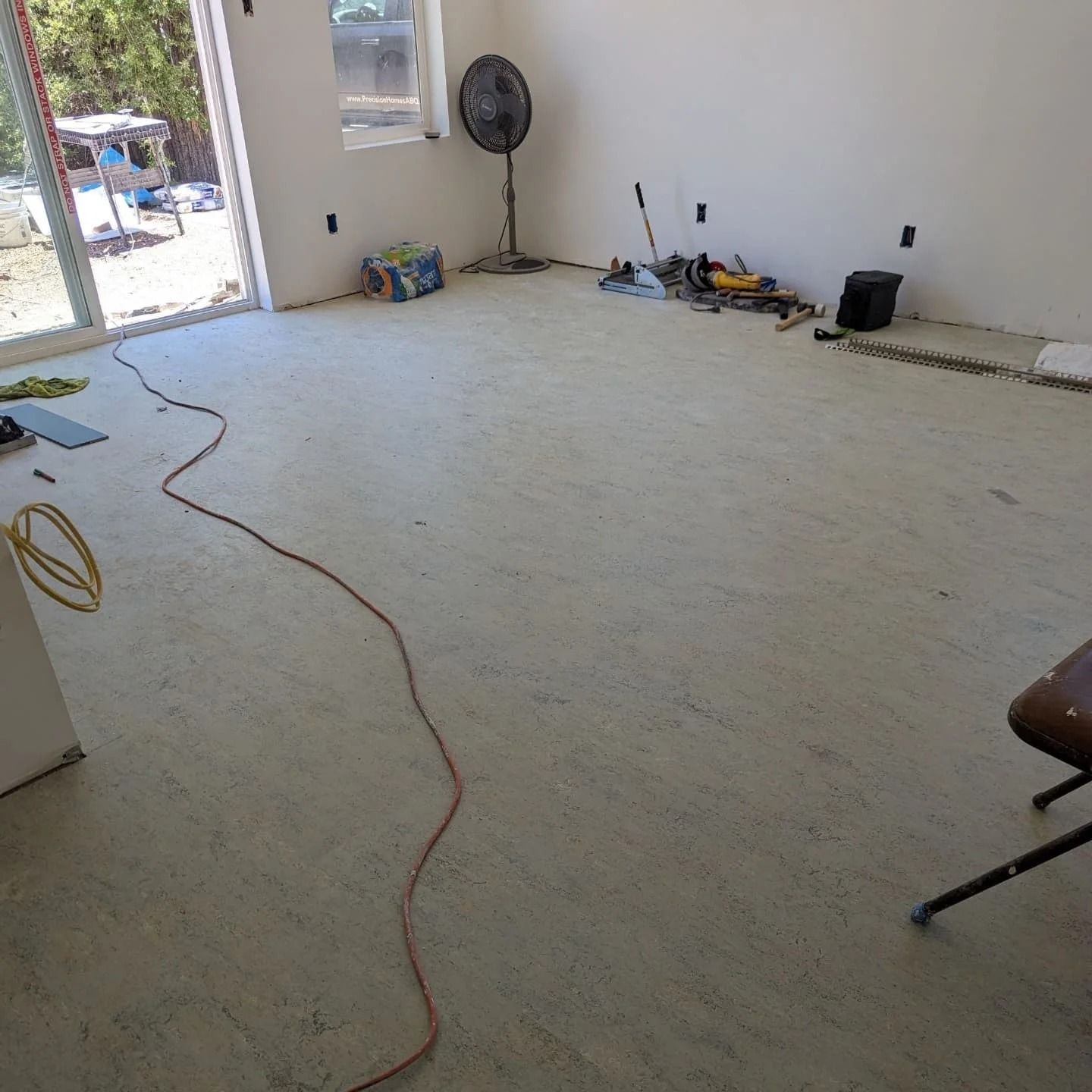 A room with a fan and a chair in it