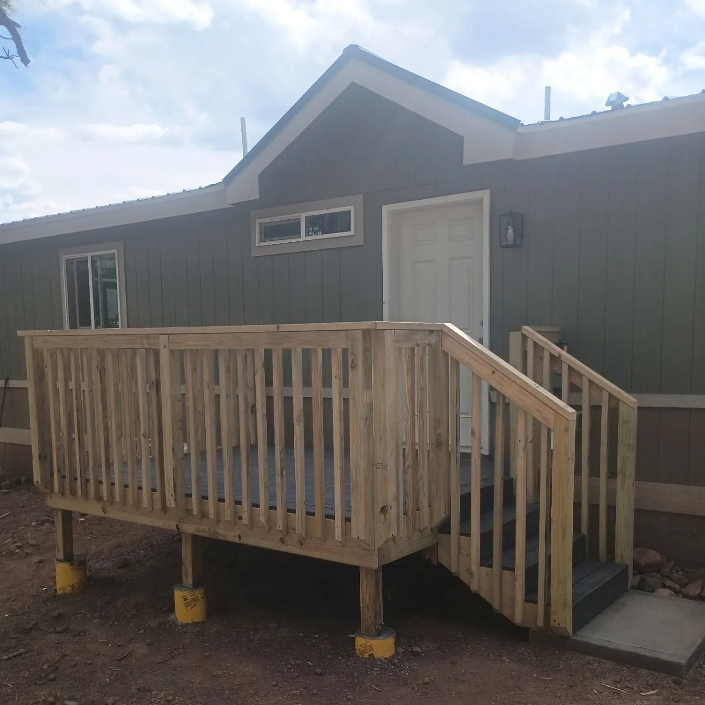 A small house with a wooden deck and stairs