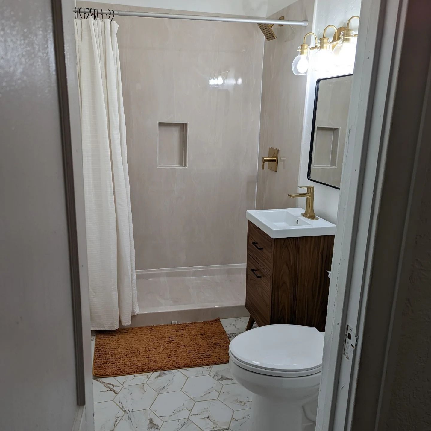 A bathroom with a toilet a sink and a shower