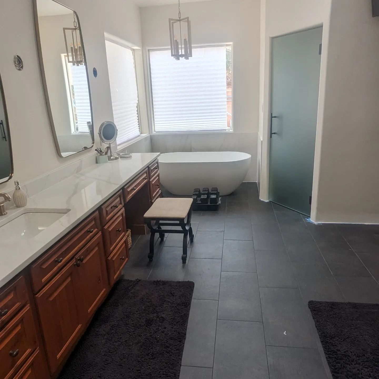 A bathroom with a tub a sink and a mirror