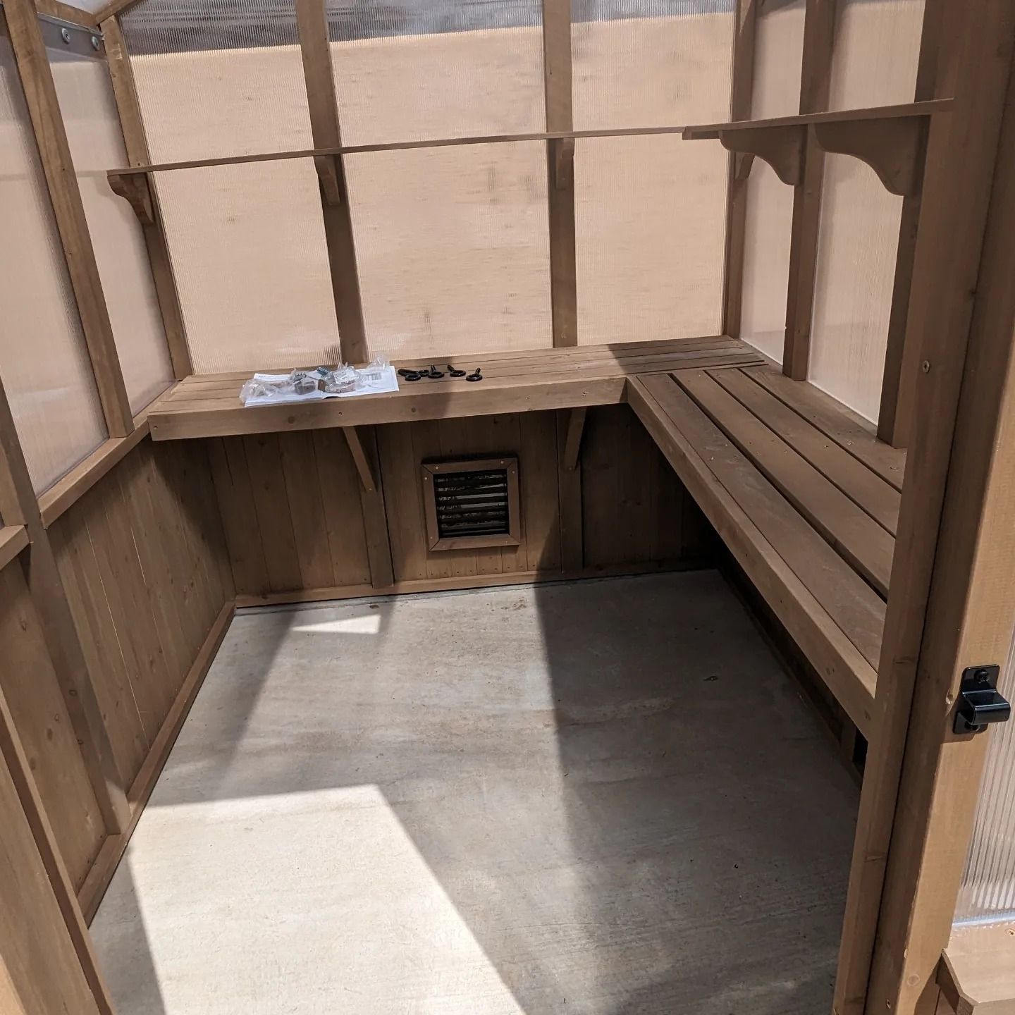 A wooden room with a bench and a window