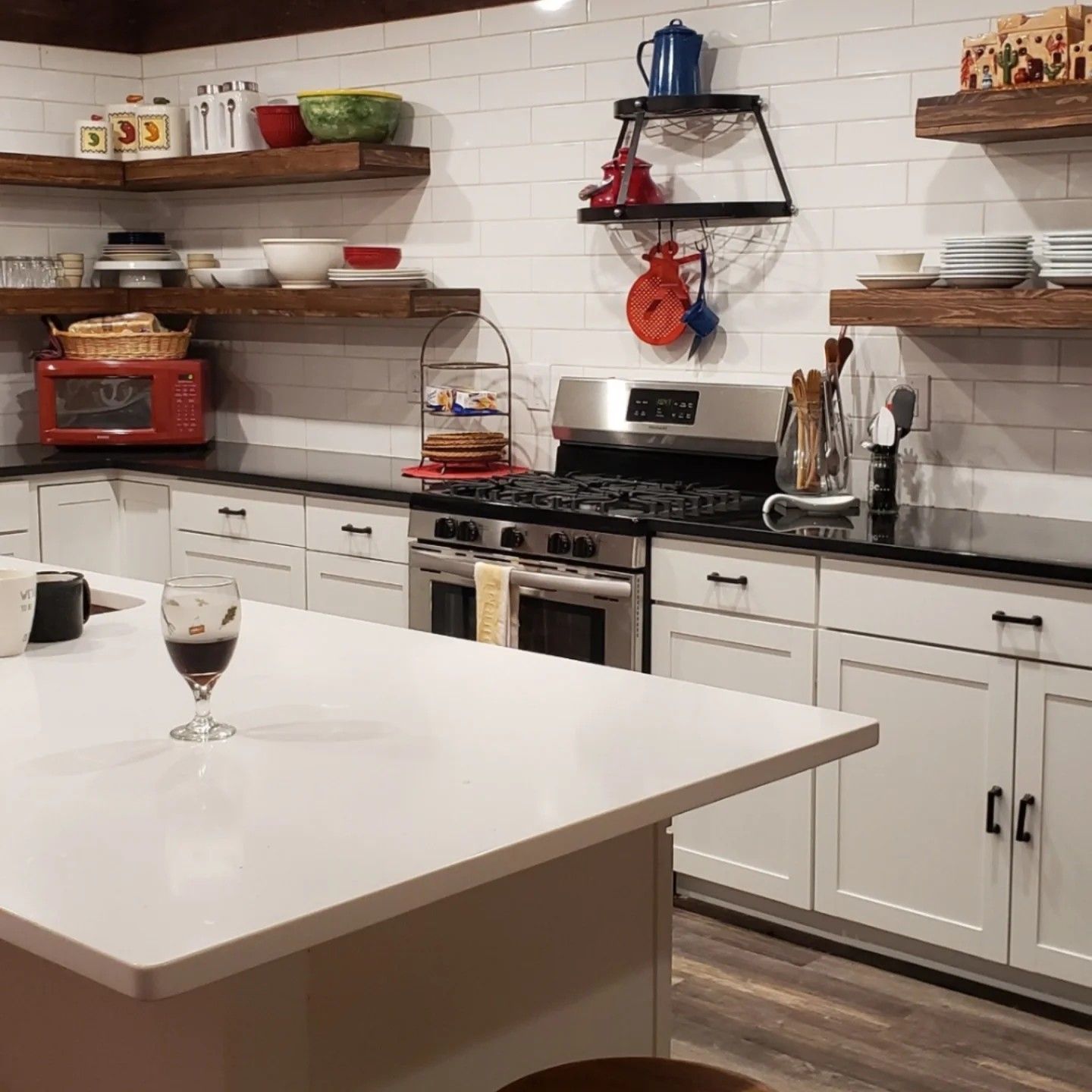 A kitchen with a glass of wine on the counter
