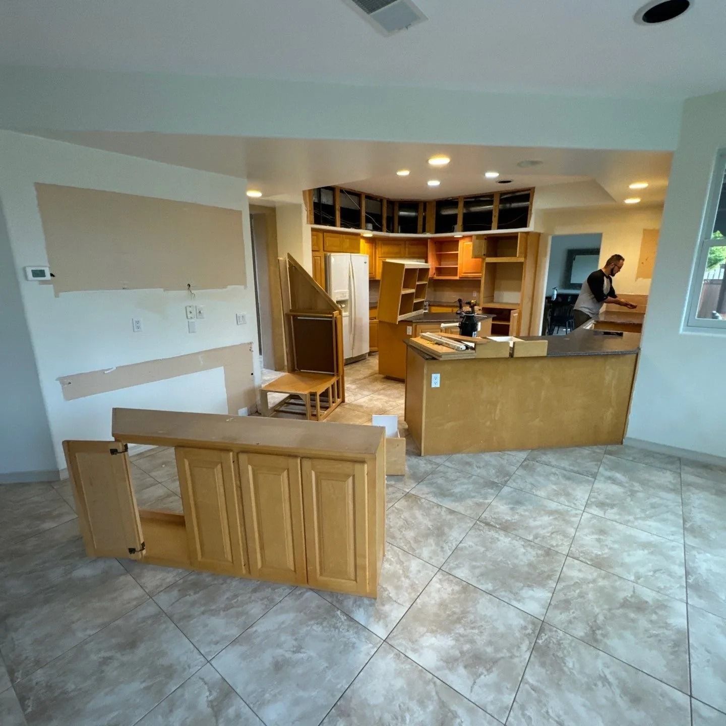 A kitchen with wooden cabinets and a tiled floor
