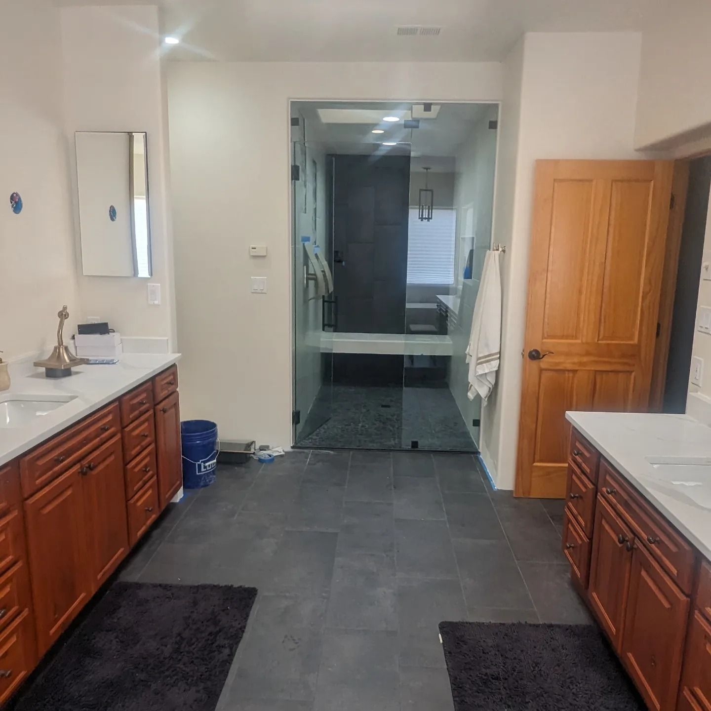 A bathroom with two sinks and a glass door