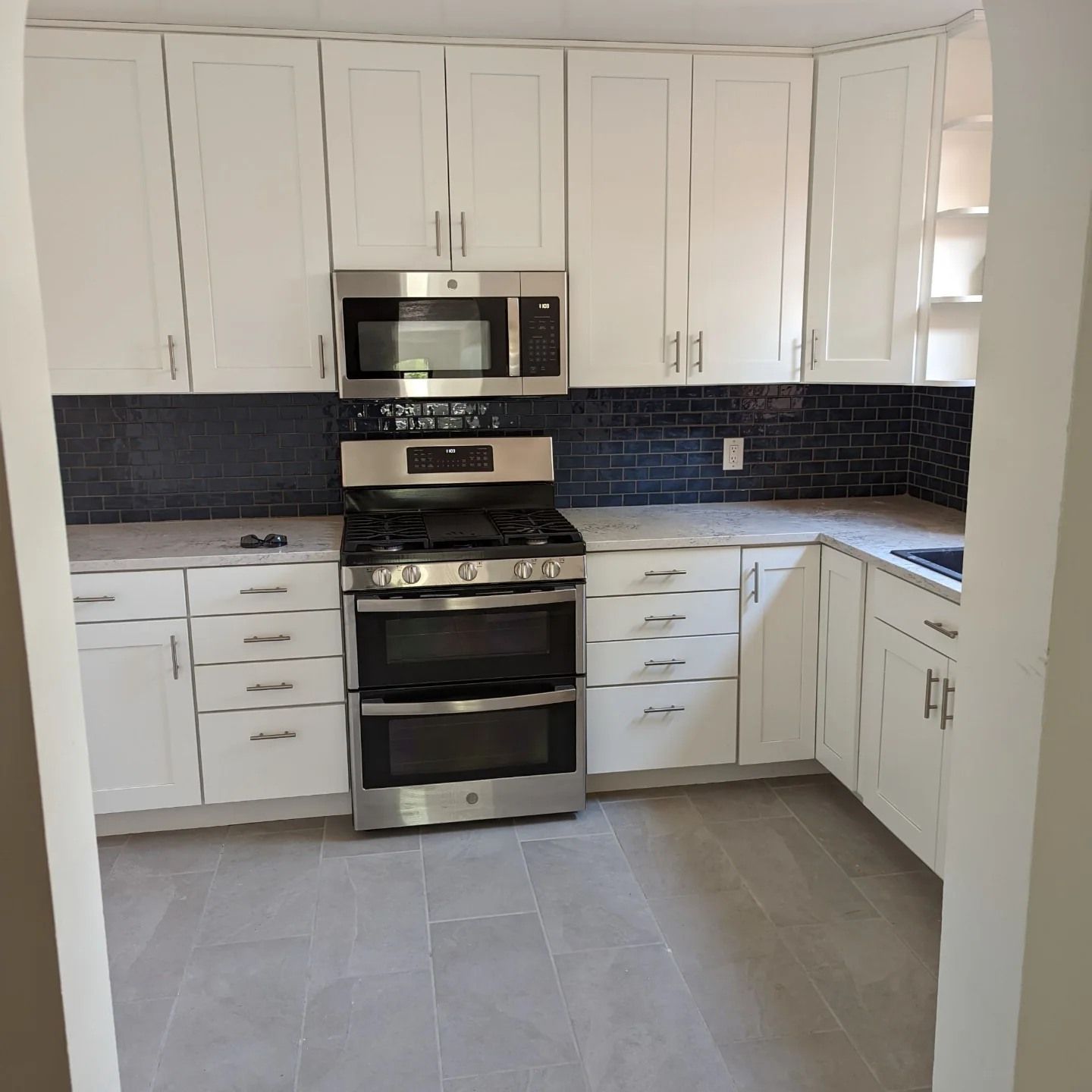 A kitchen with stainless steel appliances and white cabinets