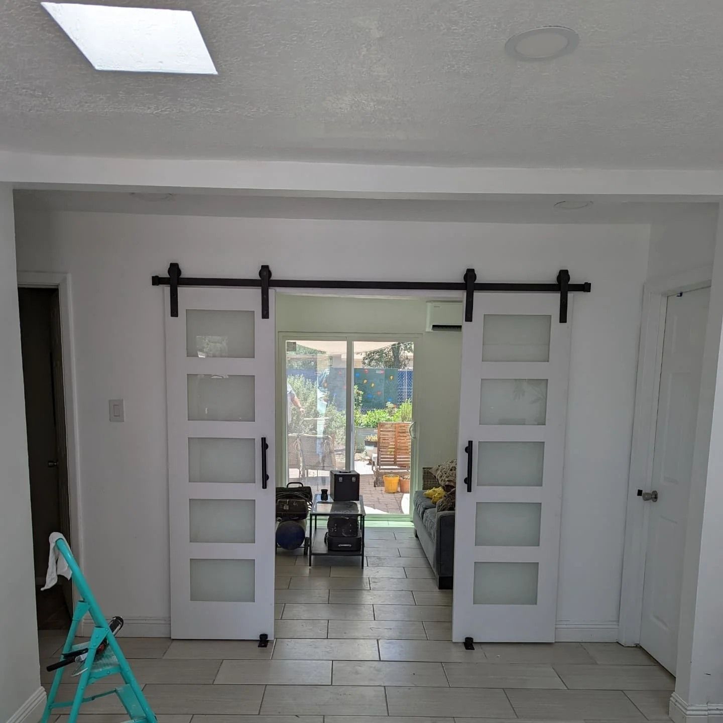 A room with sliding barn doors leading to a living room.