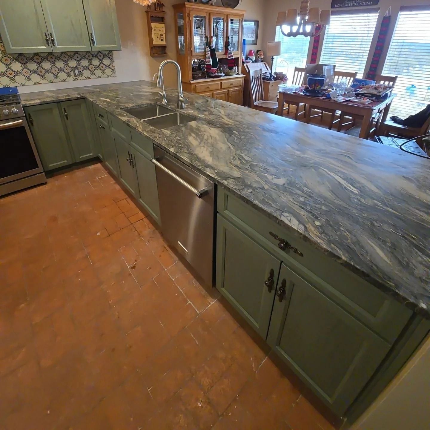 A kitchen with green cabinets and granite counter tops