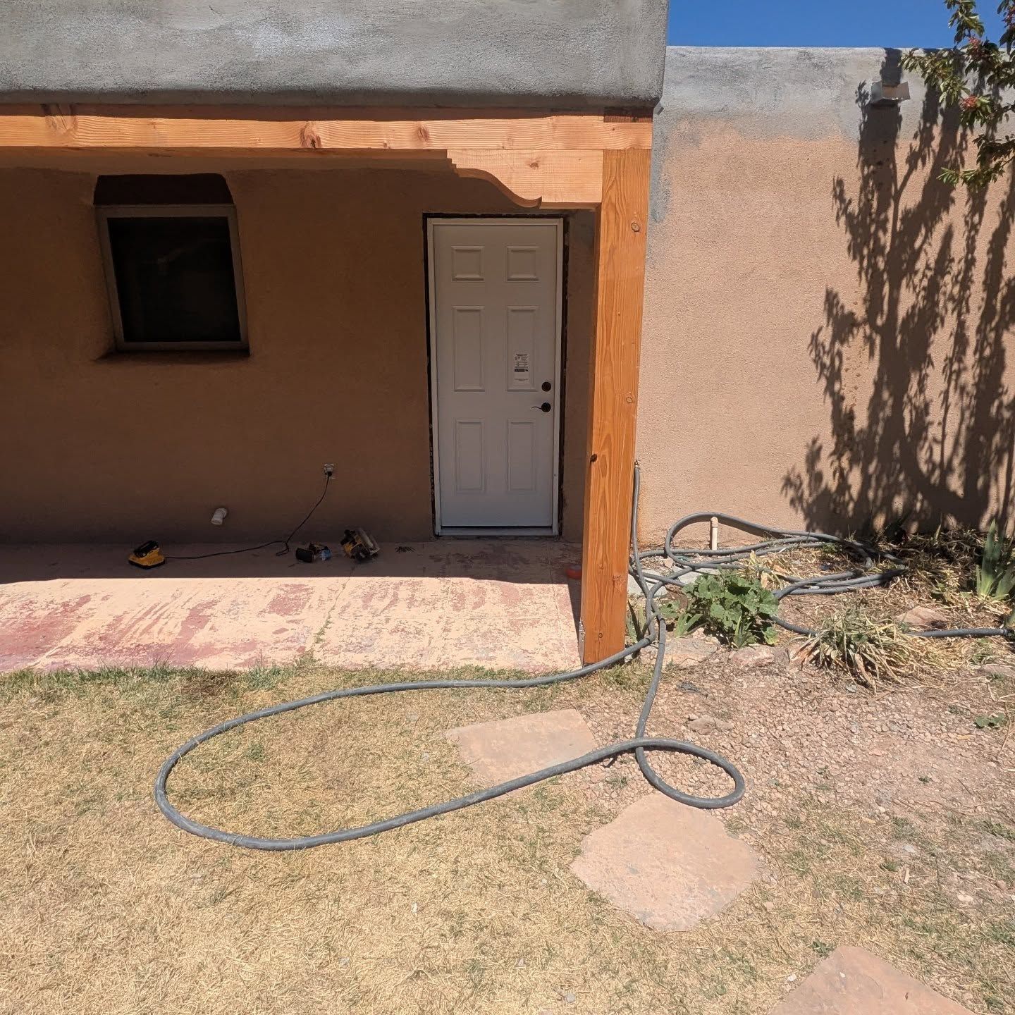 A house with a white door and a hose in front of it
