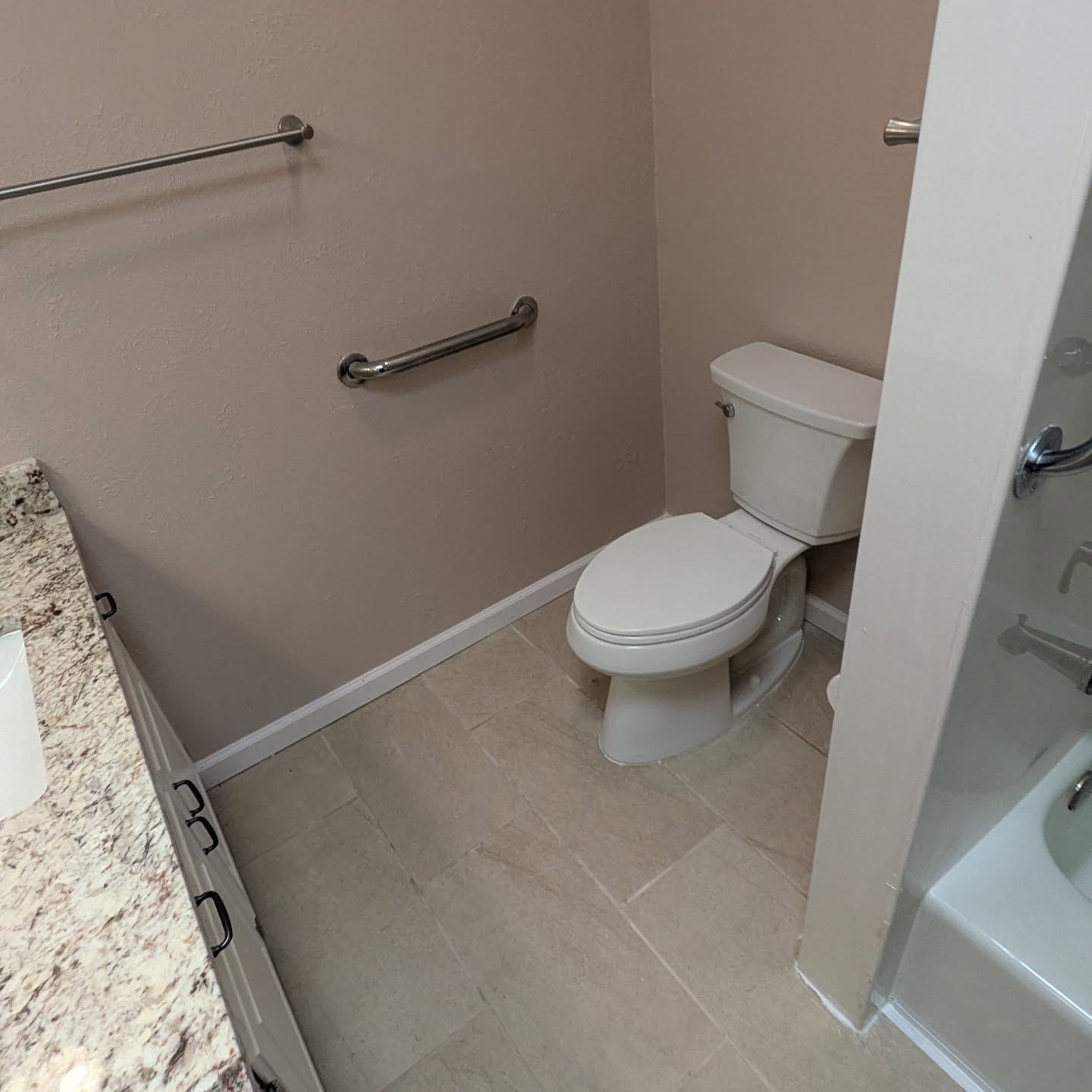 A bathroom with a toilet , sink , and bathtub.