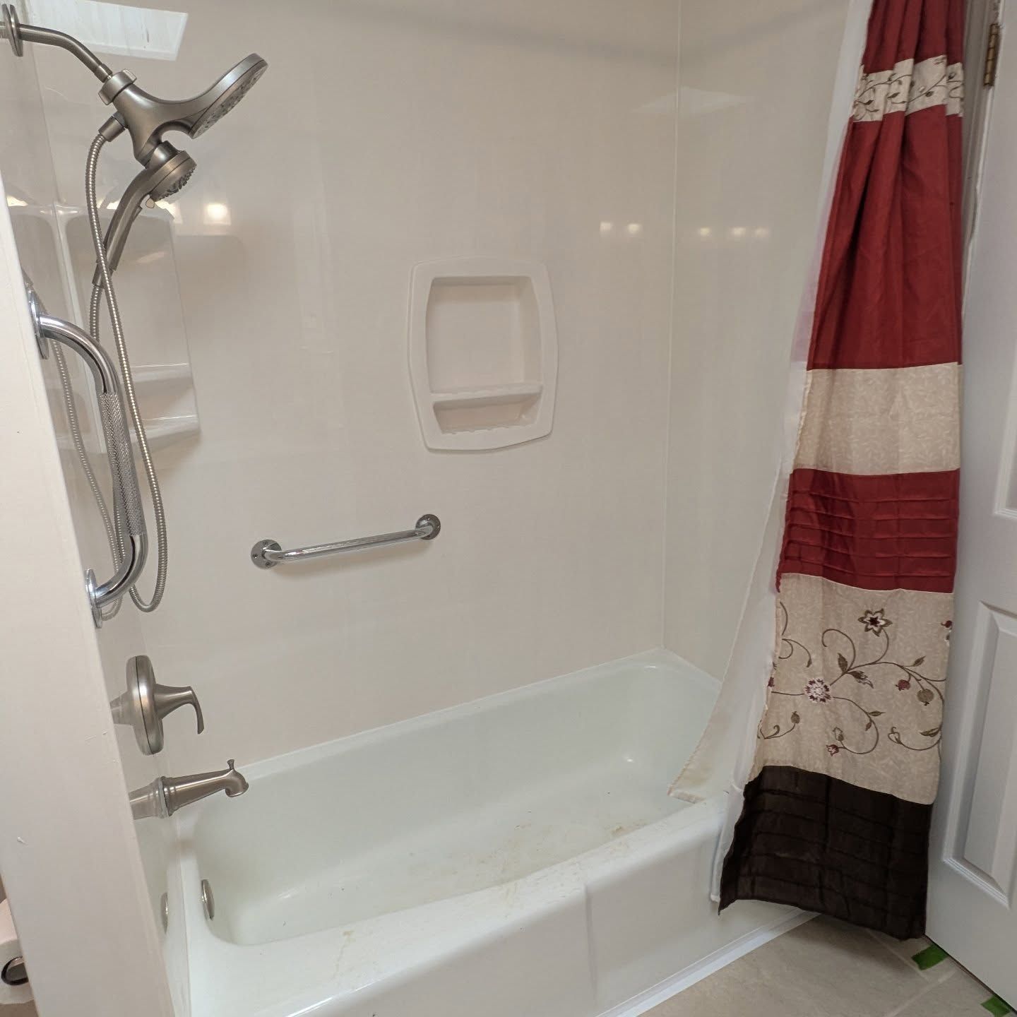 A bathroom with a bathtub and a shower head