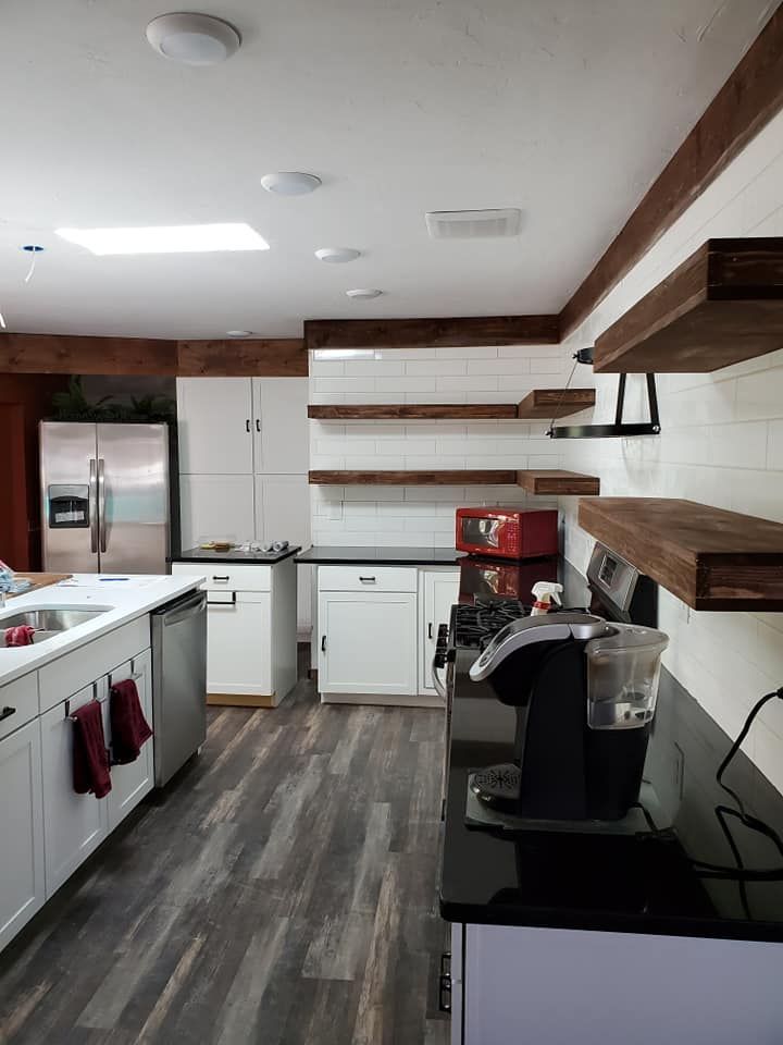 A kitchen with stainless steel appliances and wooden shelves