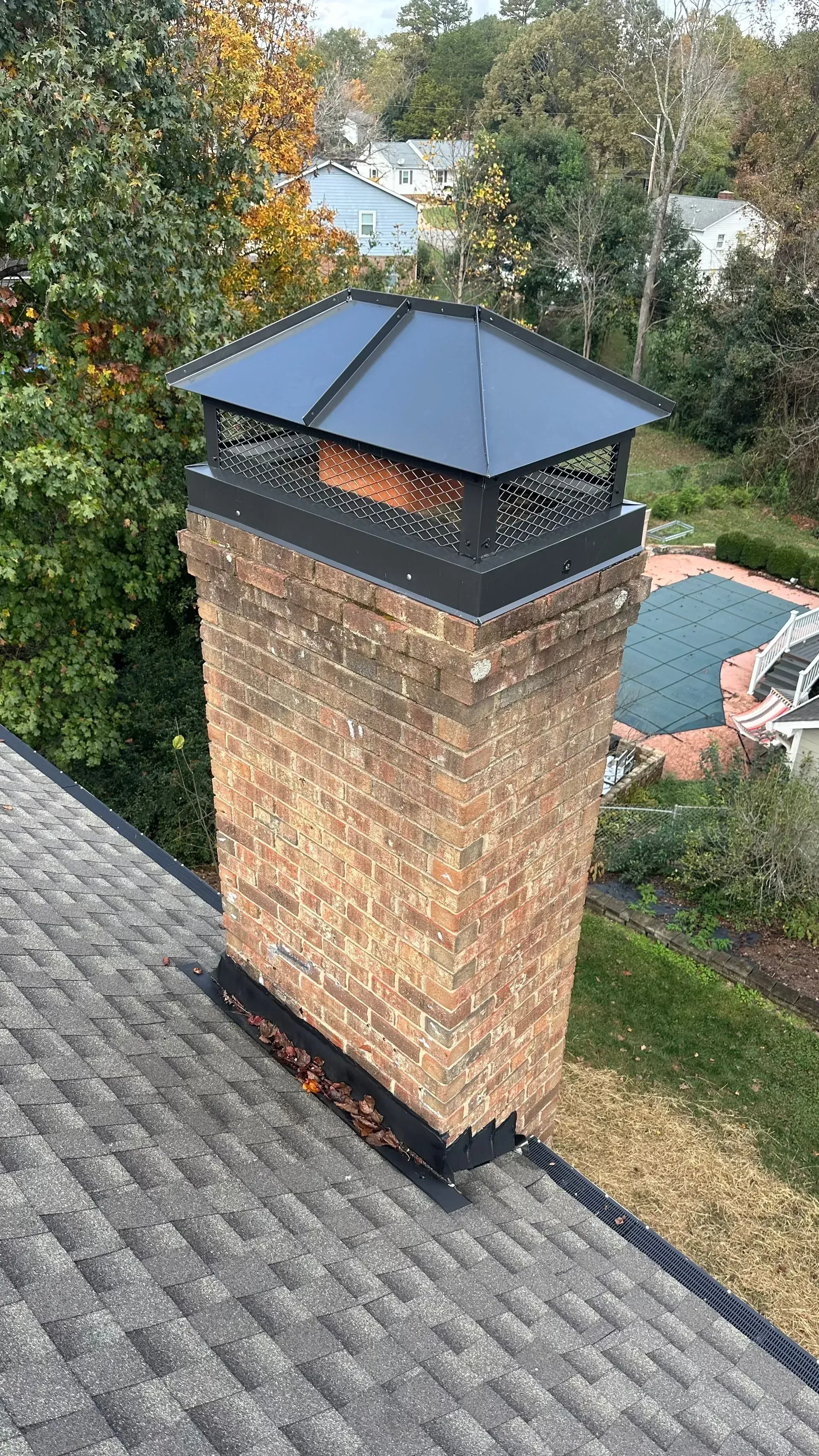 An aerial view of a brick chimney on top of a roof.