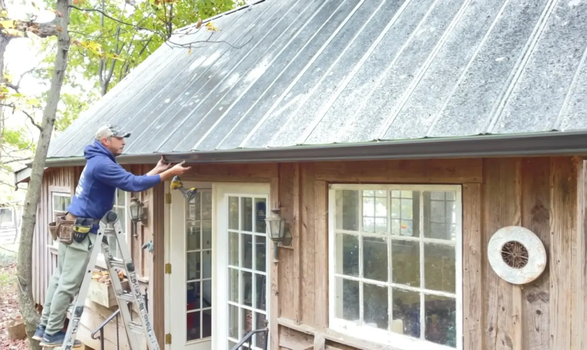 A man is working on the roof of a wooden house.