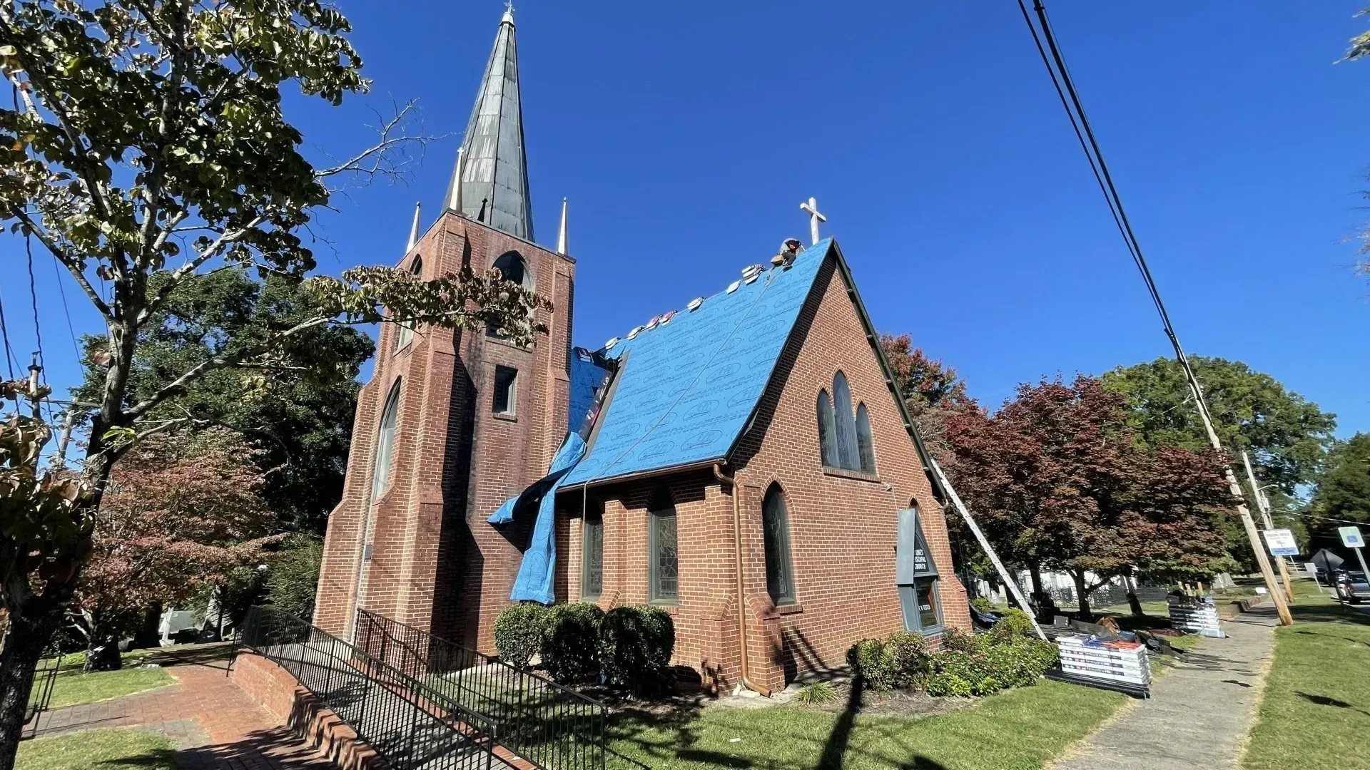 A brick church with a blue roof and a steeple