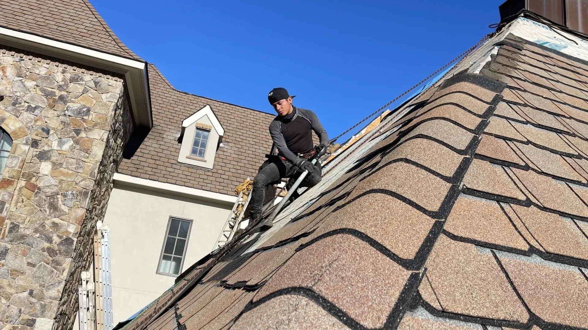 A man is standing on the roof of a house.