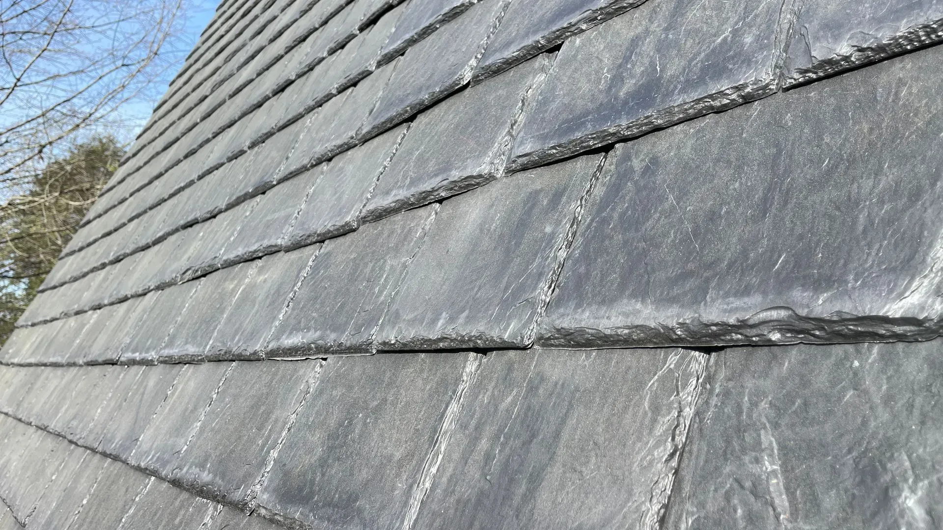 A close up of a roof with slate tiles on it.