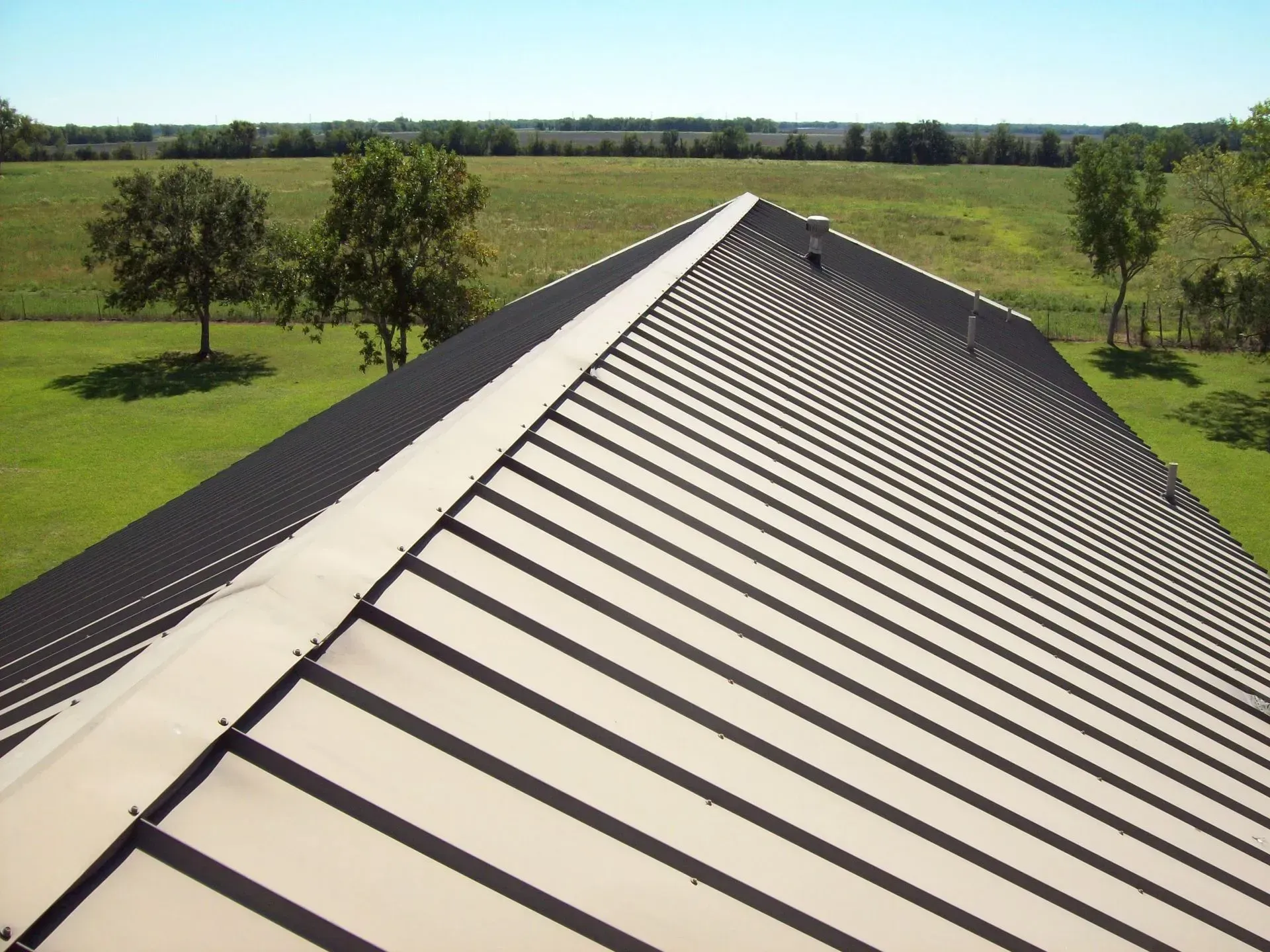 The roof of a building with a field in the background