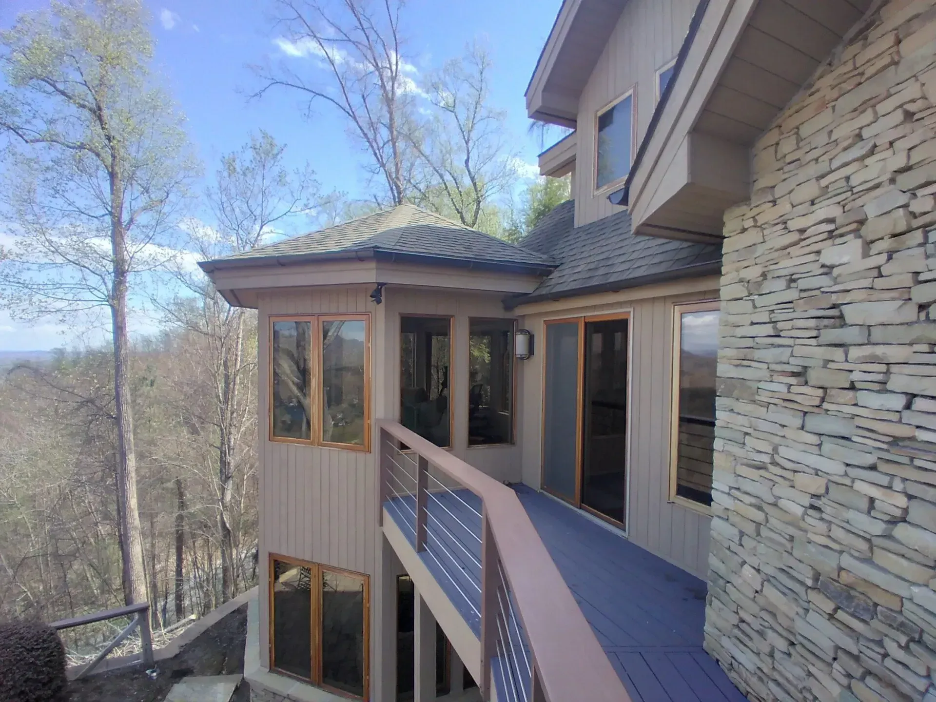 A large house with a balcony and a stone wall