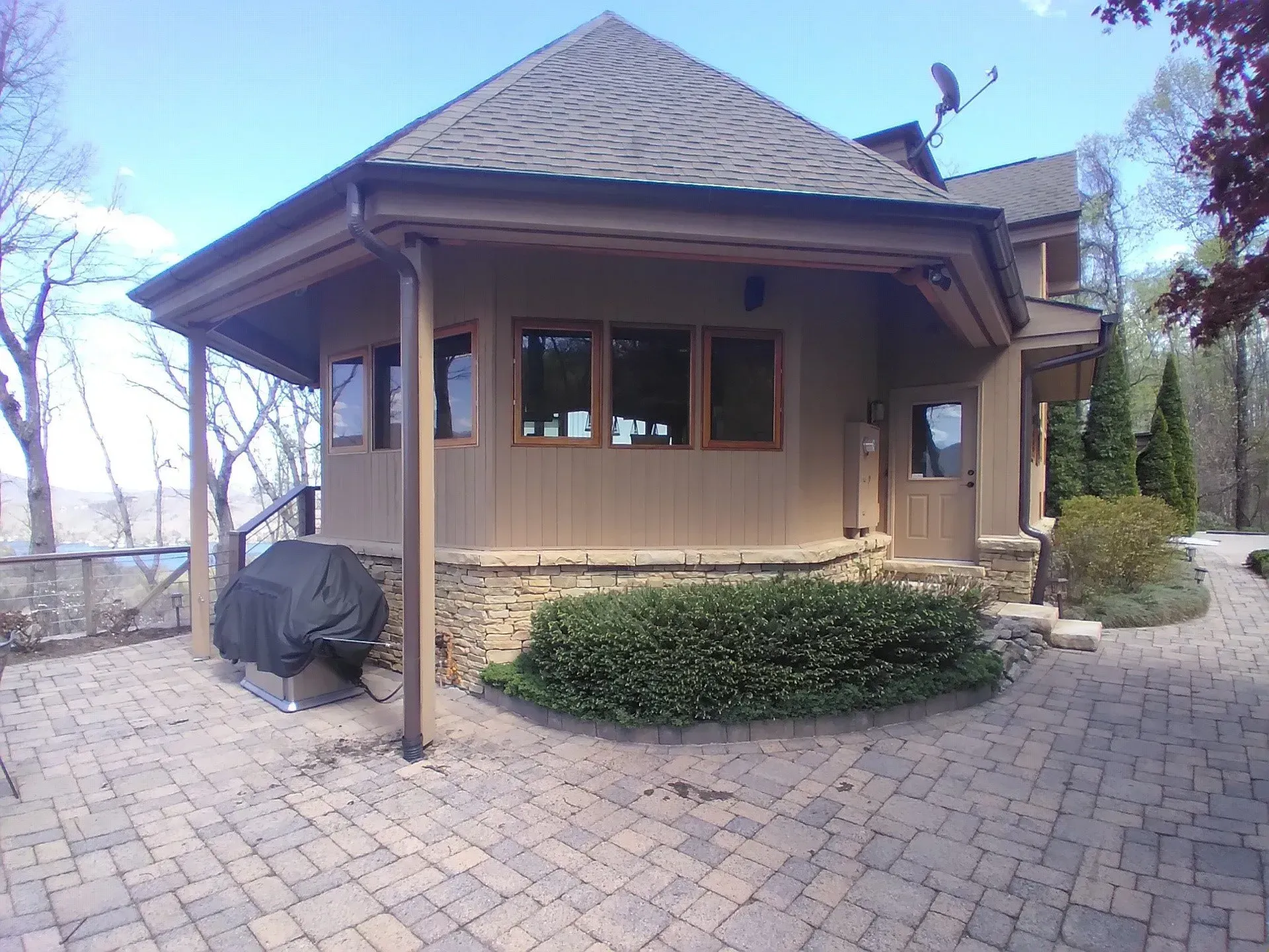 A large house with a lot of windows and a brick driveway