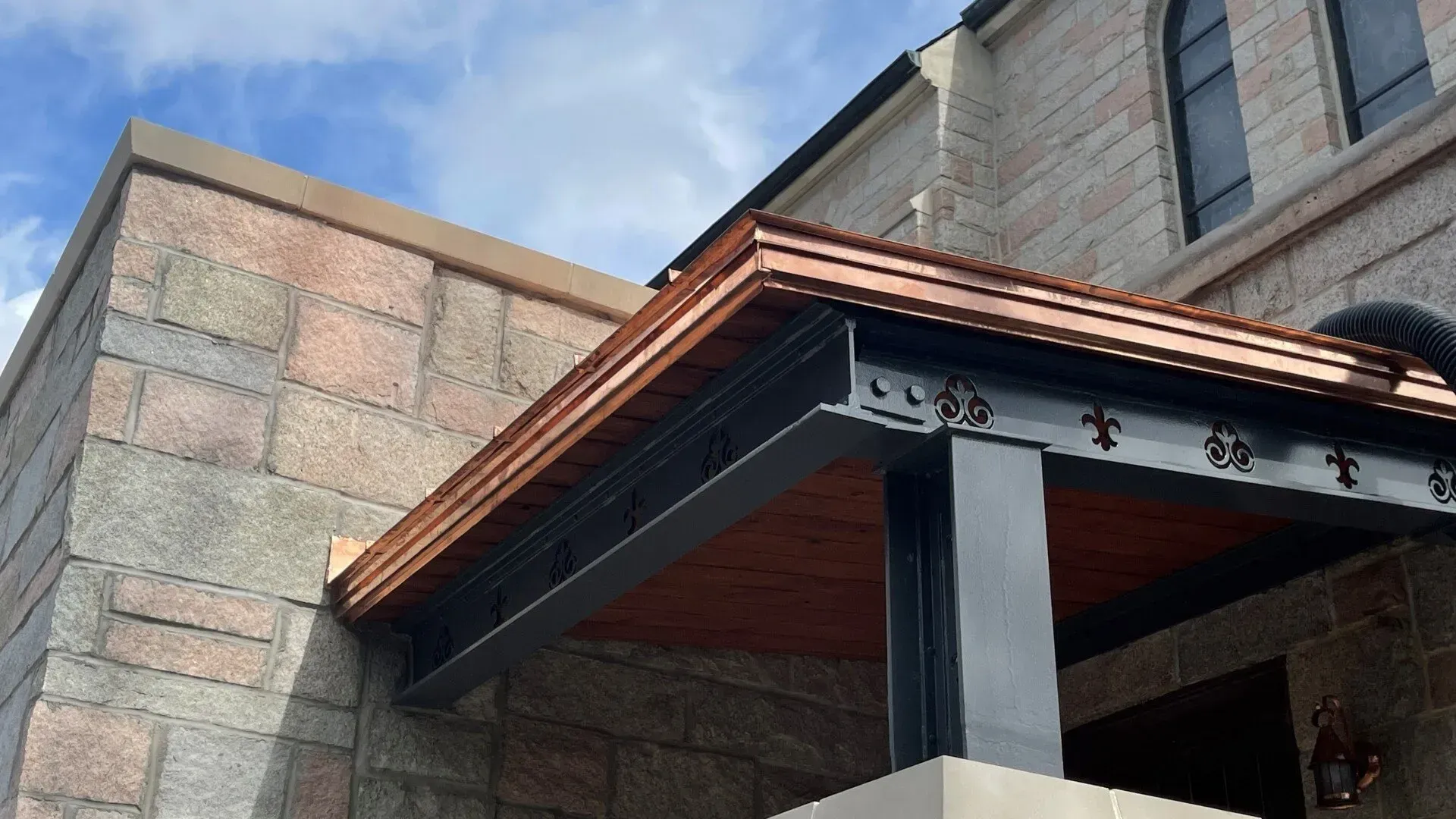 A brick building with a copper roof and gutters