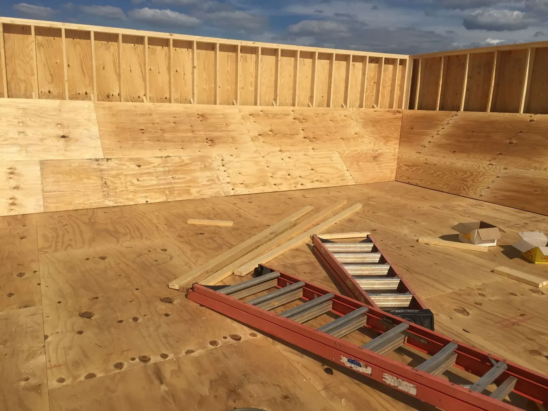 A ladder is laying on the floor of a room under construction