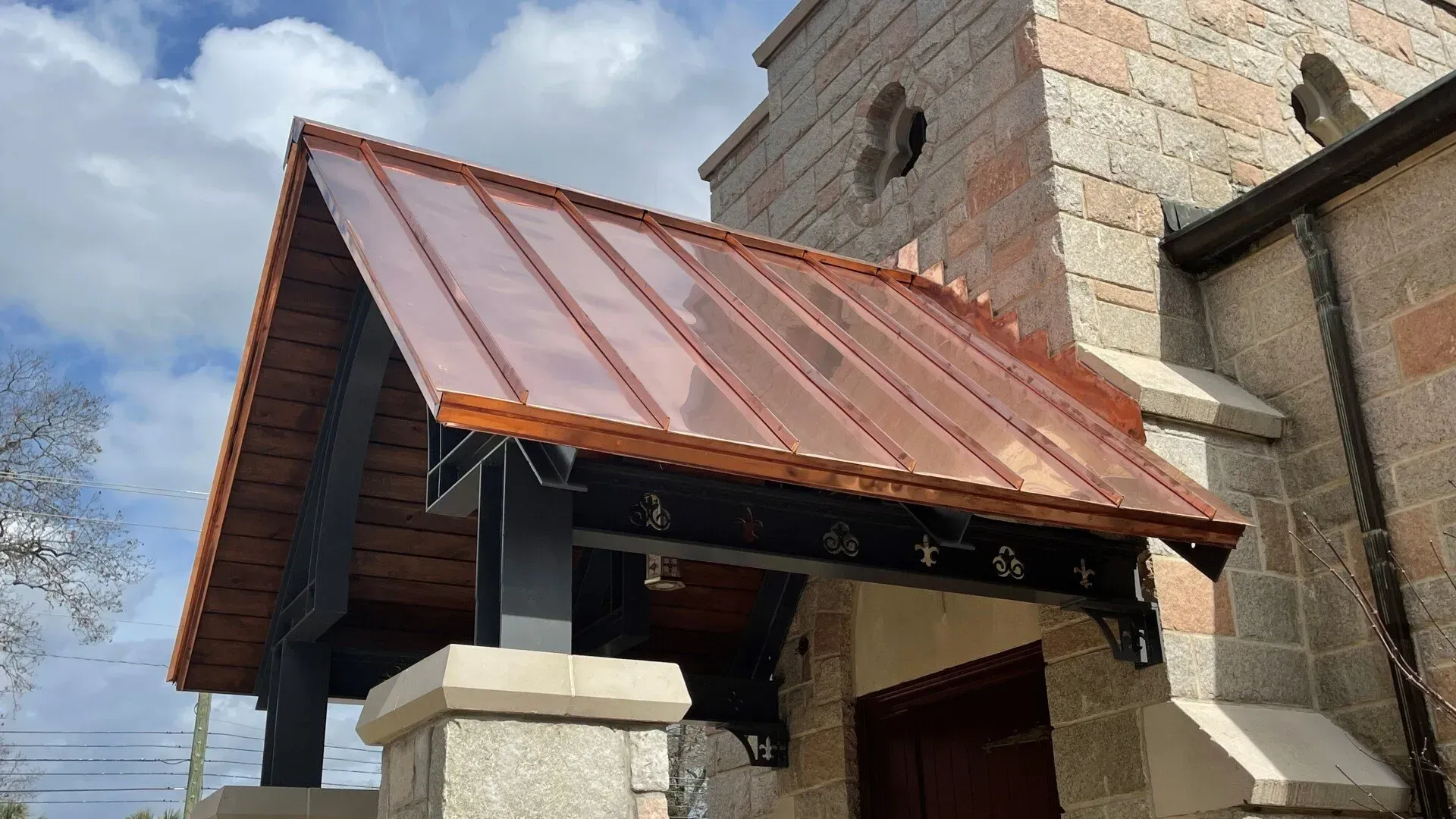 A building with a copper roof and a brick wall