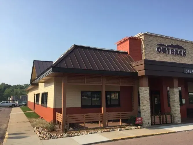 A restaurant called outback is located on the side of the road.