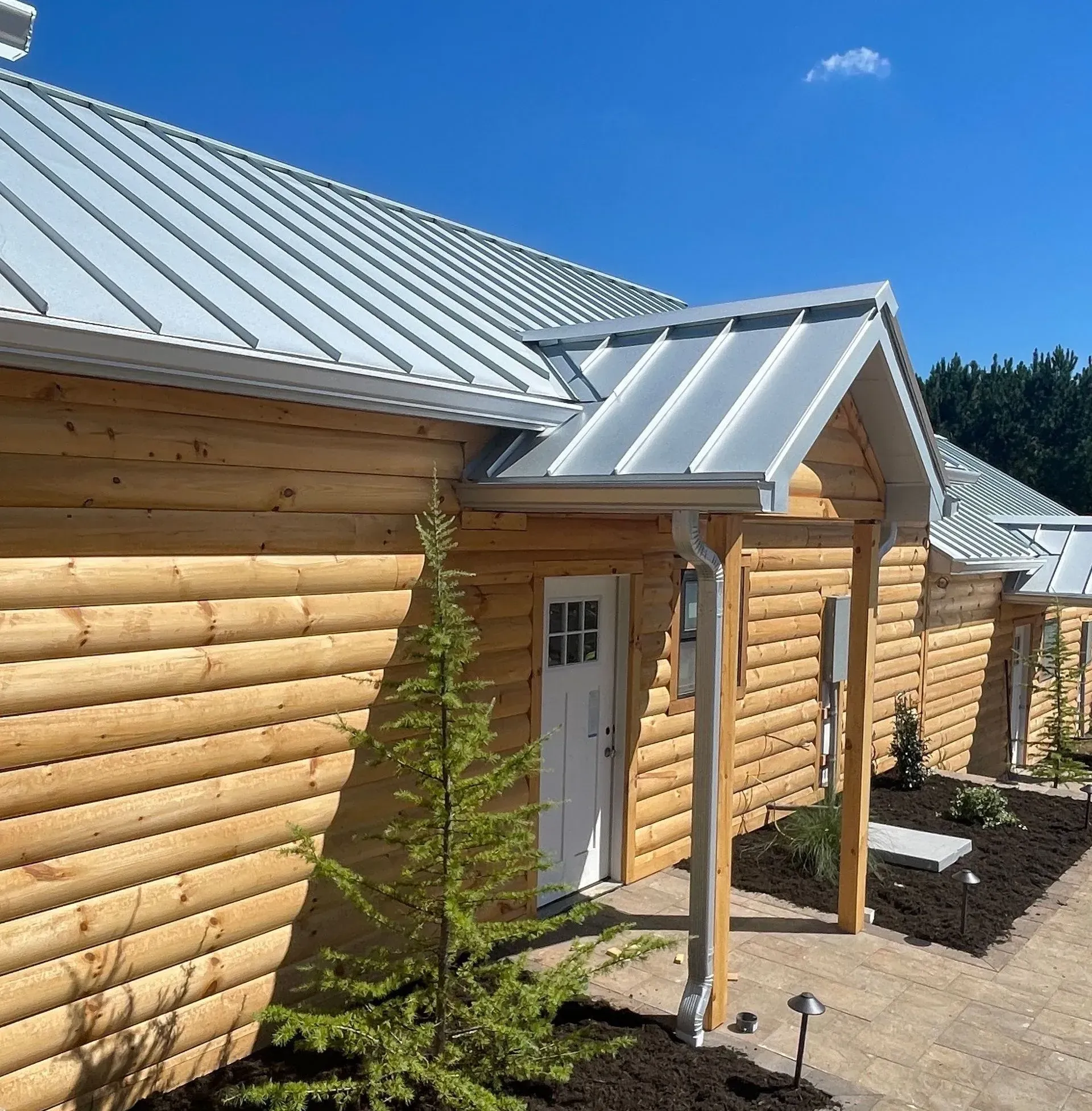 A log cabin with a metal roof and a white door