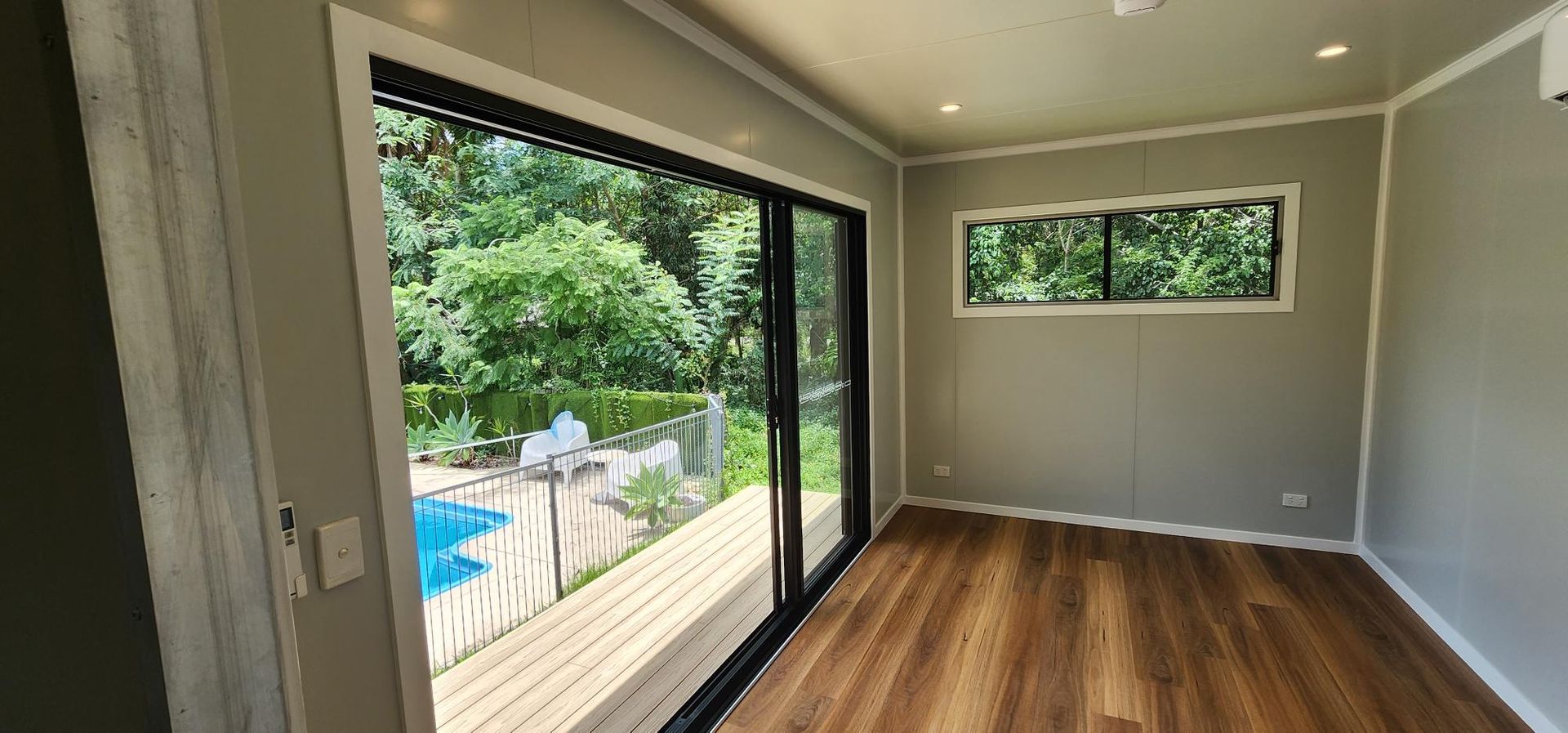 A Room with A Sliding Glass Door and A View of A Pool — Alternative Modular Home In Toowoomba City, QLD