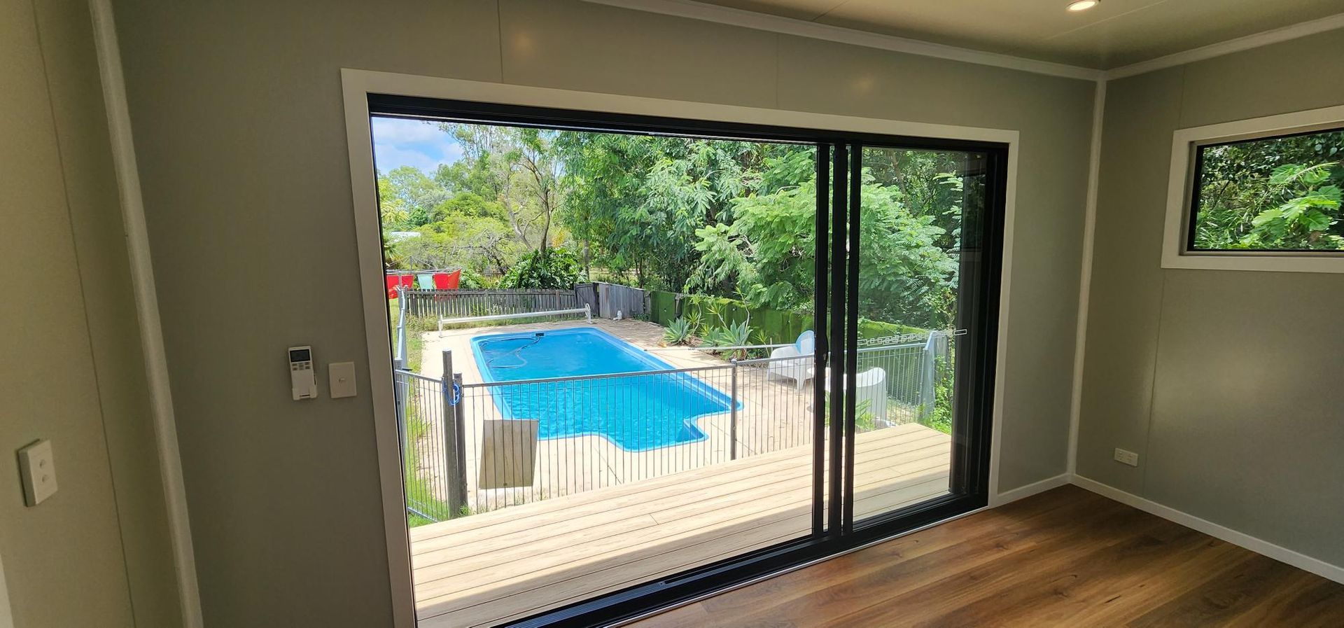 A Room with A Sliding Glass Door Leading to A Swimming Pool — Alternative Modular Home In Toowoomba City, QLD