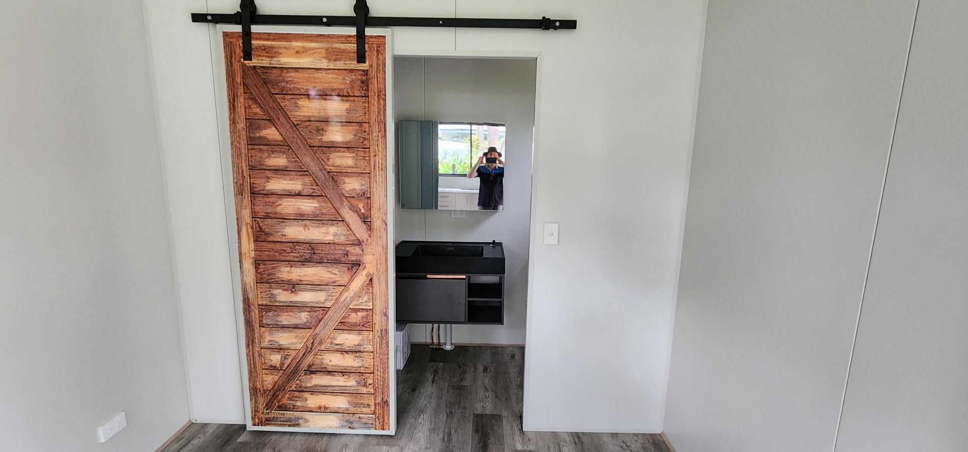 A Sliding Barn Door in A Room Leading to A Bathroom — Alternative Modular Home In Toowoomba City, QLD