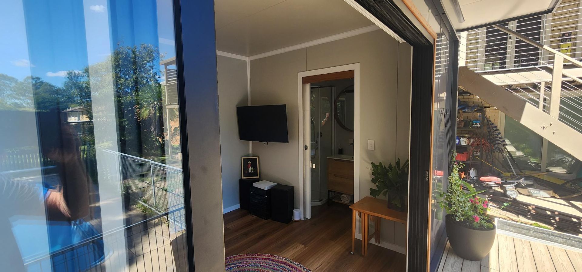 A Living Room with A Sliding Glass Door and A Flat Screen TV — Alternative Modular Home In Toowoomba City, QLD