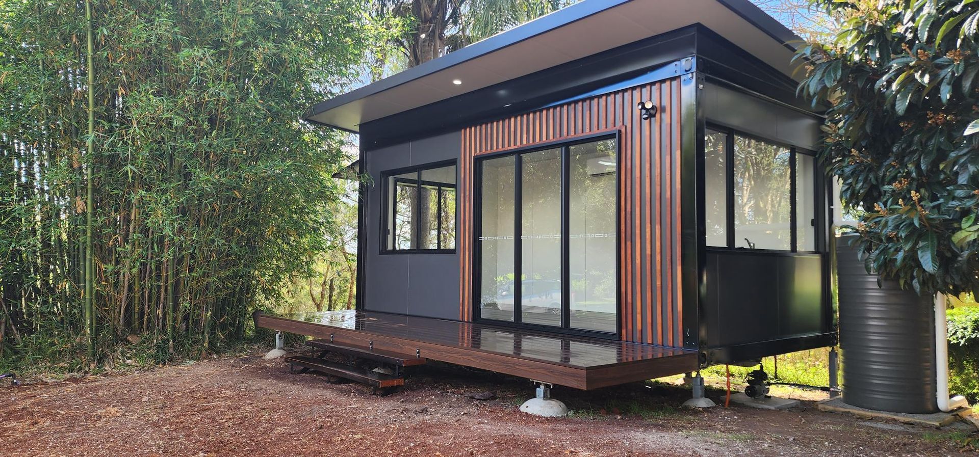 A Small House with A Lot of Windows Is Sitting in The Middle of A Forest — Alternative Modular Home In Toowoomba City, QLD