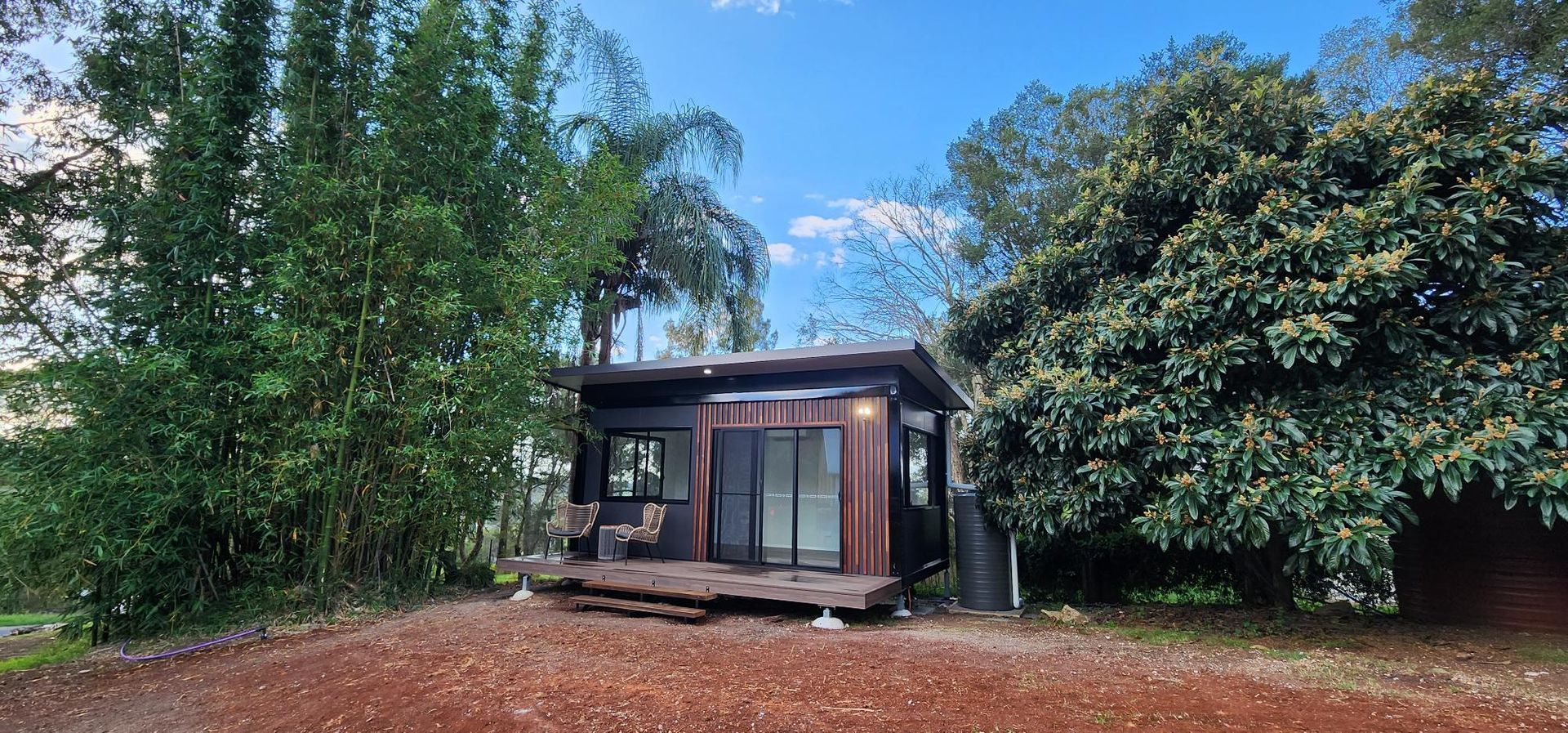 A Small House Is Sitting in The Middle of A Forest Surrounded by Trees — Alternative Modular Home In Toowoomba City, QLD