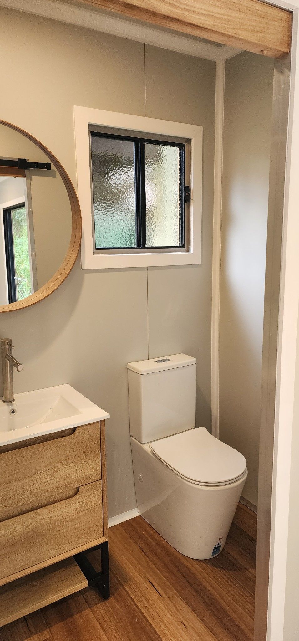 A Bathroom with A Toilet , Sink , Mirror and Window — Alternative Modular Home In Toowoomba City, QLD