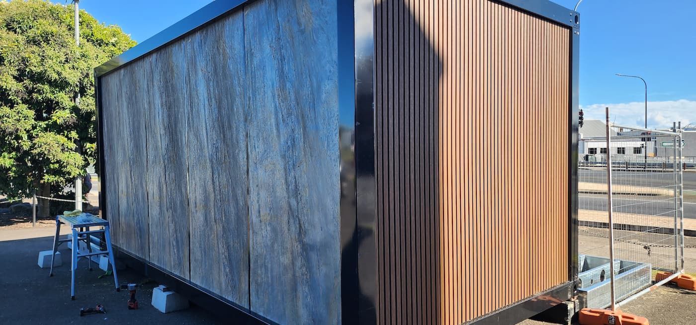 A Wooden Building Is Being Painted in A Parking Lot — Alternative Modular Home In Toowoomba City, QLD