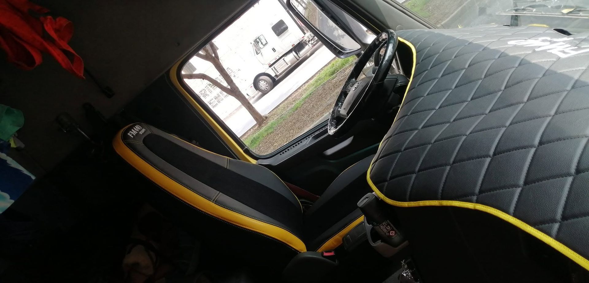 Asiento de coche con funda negra cosida en forma de diamante y ribete amarillo