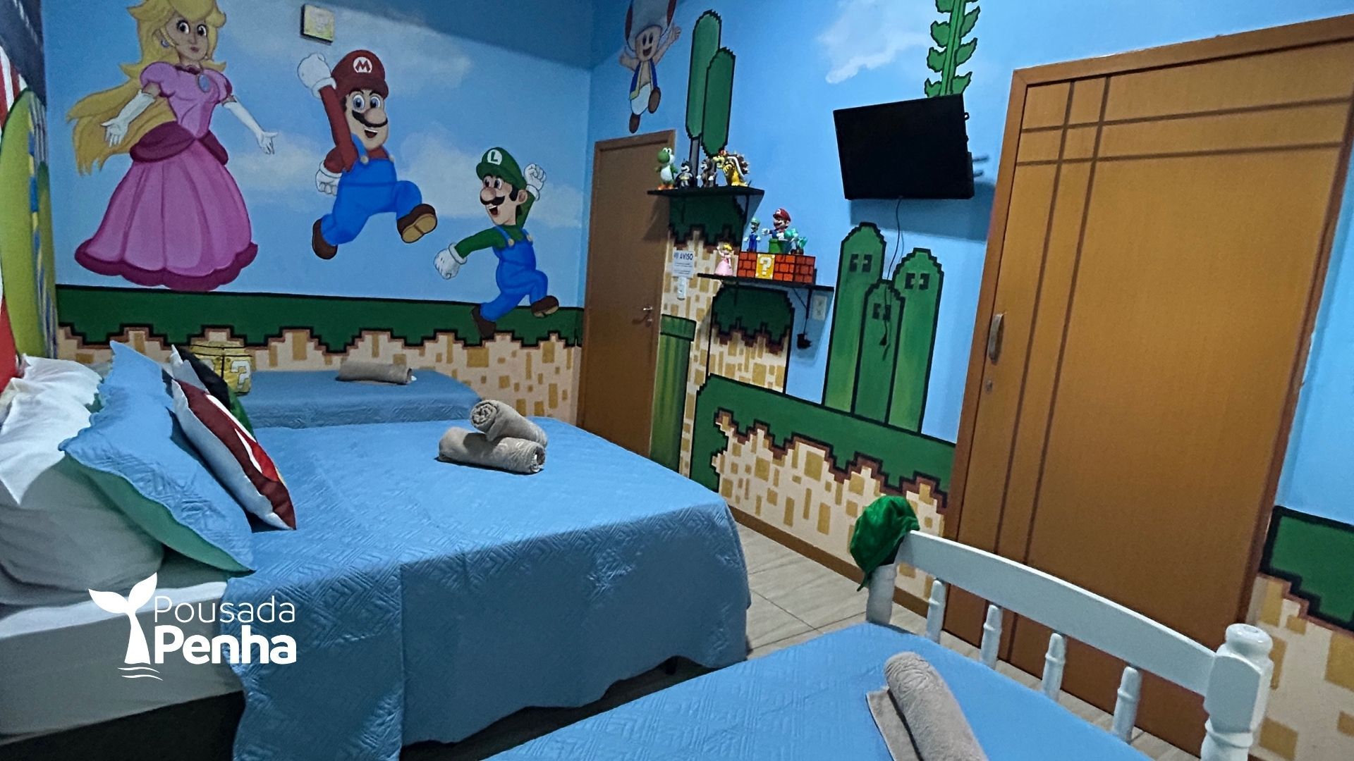 Um quarto temático inspirado no Super Mario, com murais nas paredes representando Mario, Luigi e a Princesa Peach, e duas camas arrumadas.