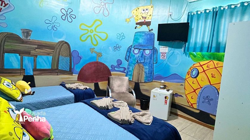 Um quarto temático inspirado no Bob Esponja, com paredes pintadas, uma casa de abacaxi, a casa do Lula Molusco e duas camas.