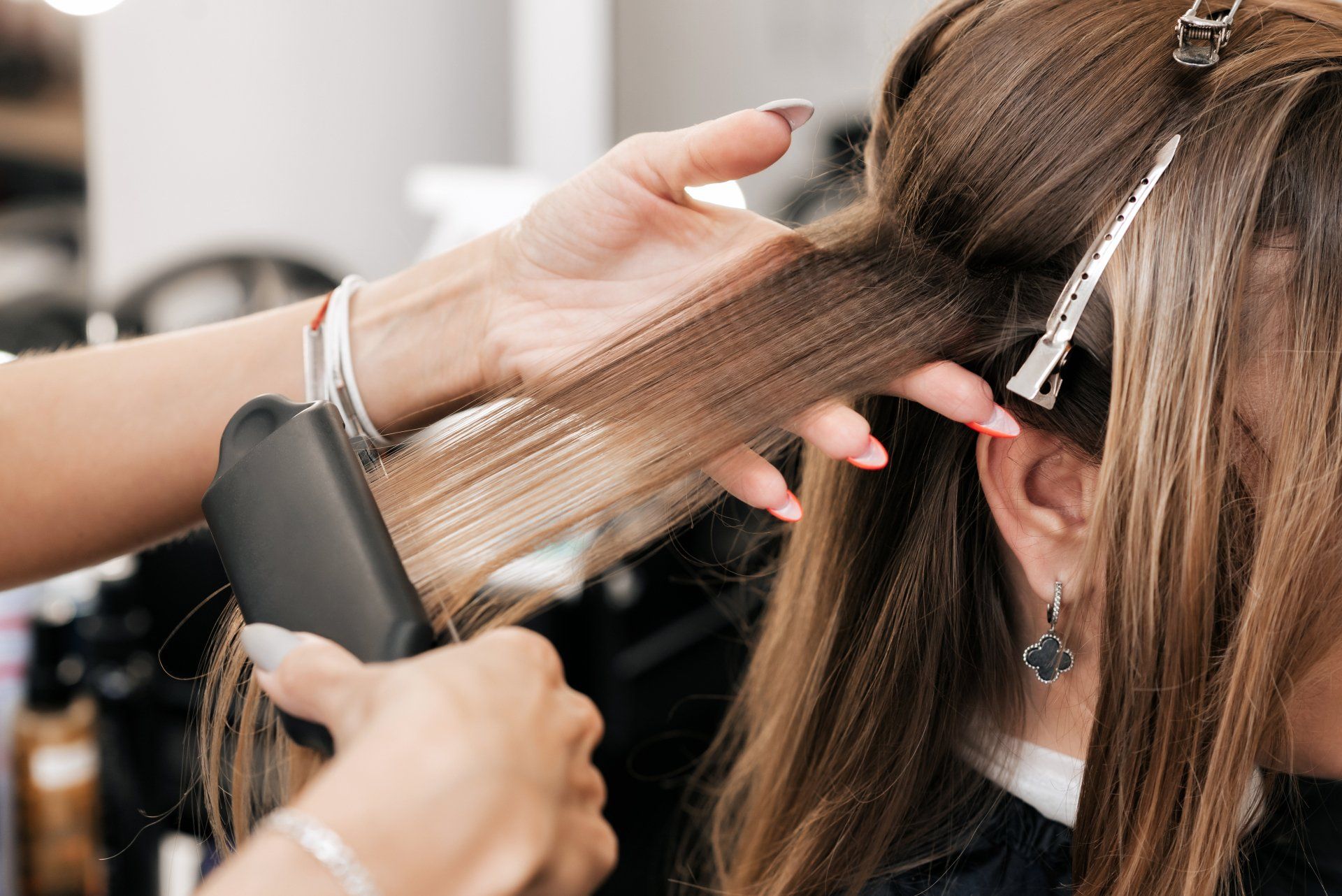hair stylist creates volume and styling for brown hair on a woman's head in a beauty salon