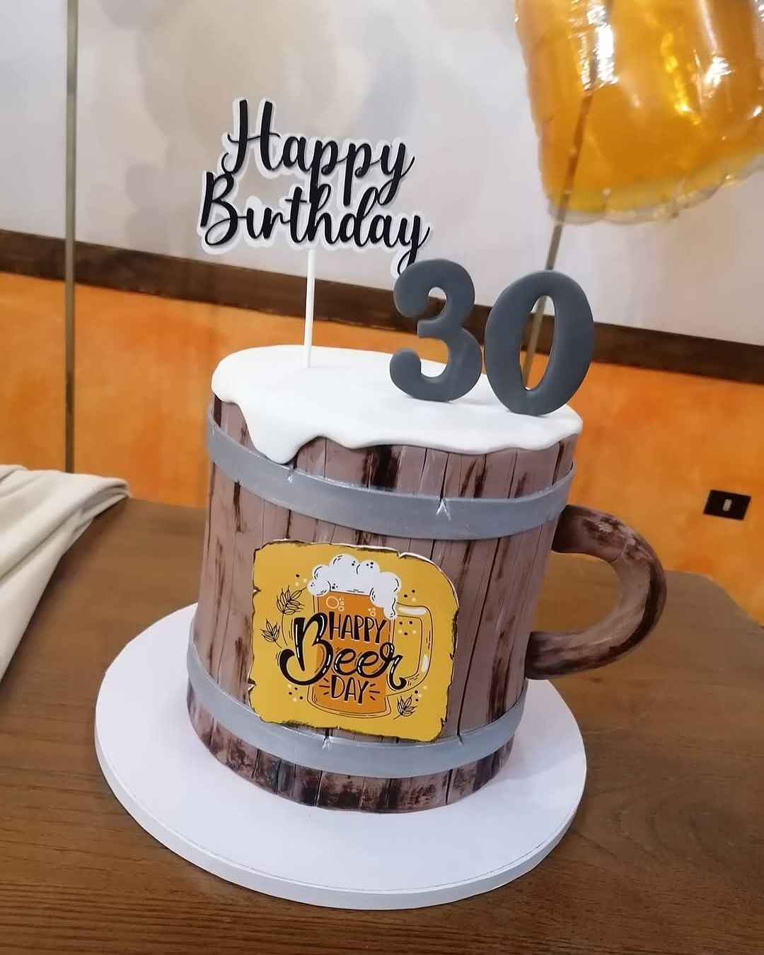 Una torta di compleanno a forma di boccale di birra con il numero 30 in cima