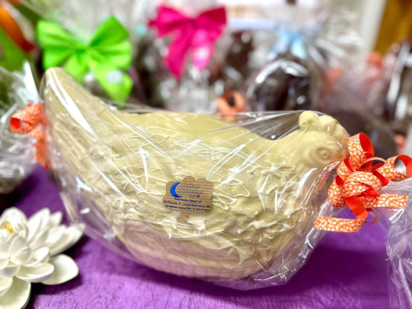 Un uccellino di cioccolato bianco è avvolto nella plastica e legato con un fiocco.
