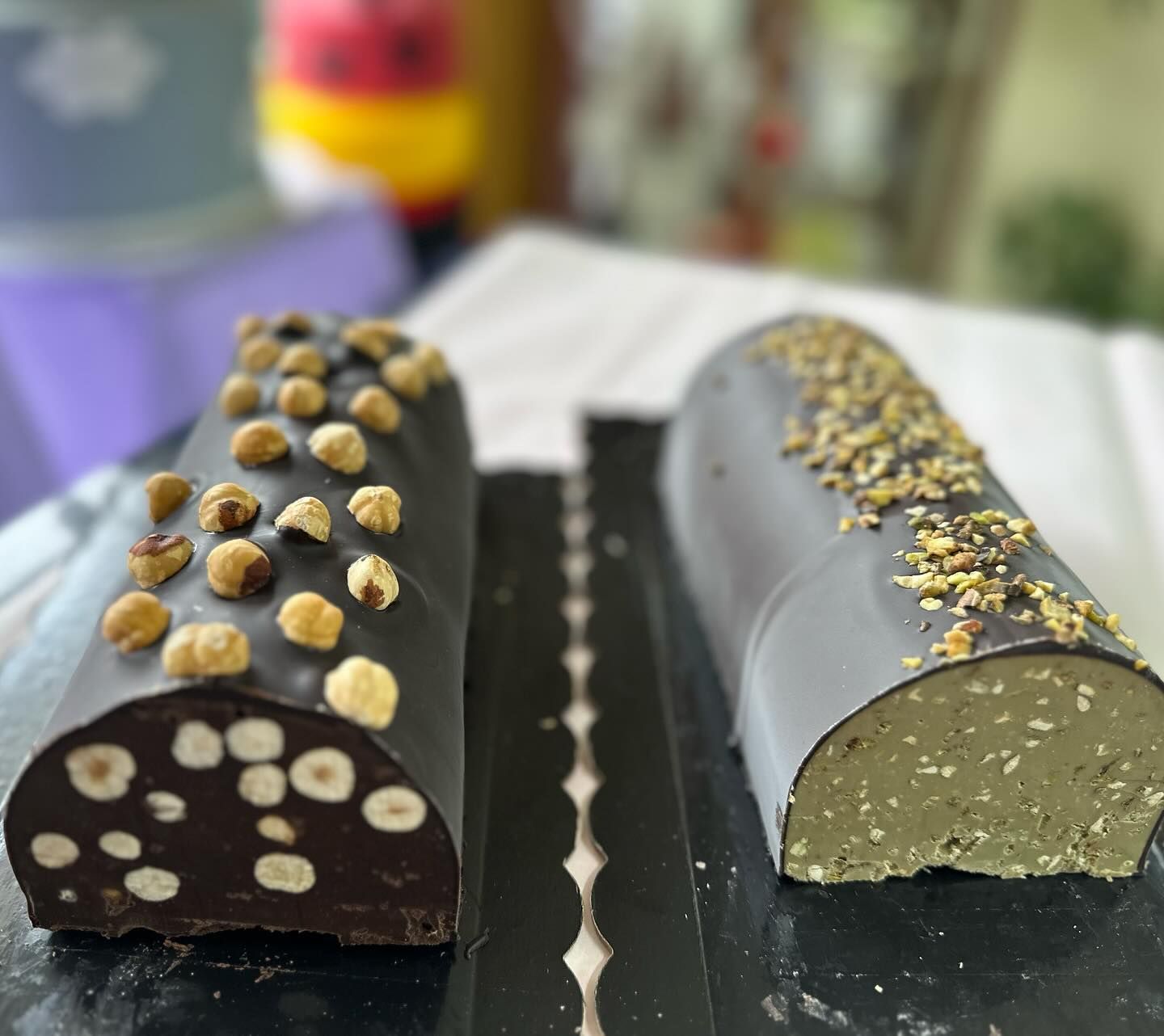Due rotoli di cioccolato con sopra delle noci su un tavolo