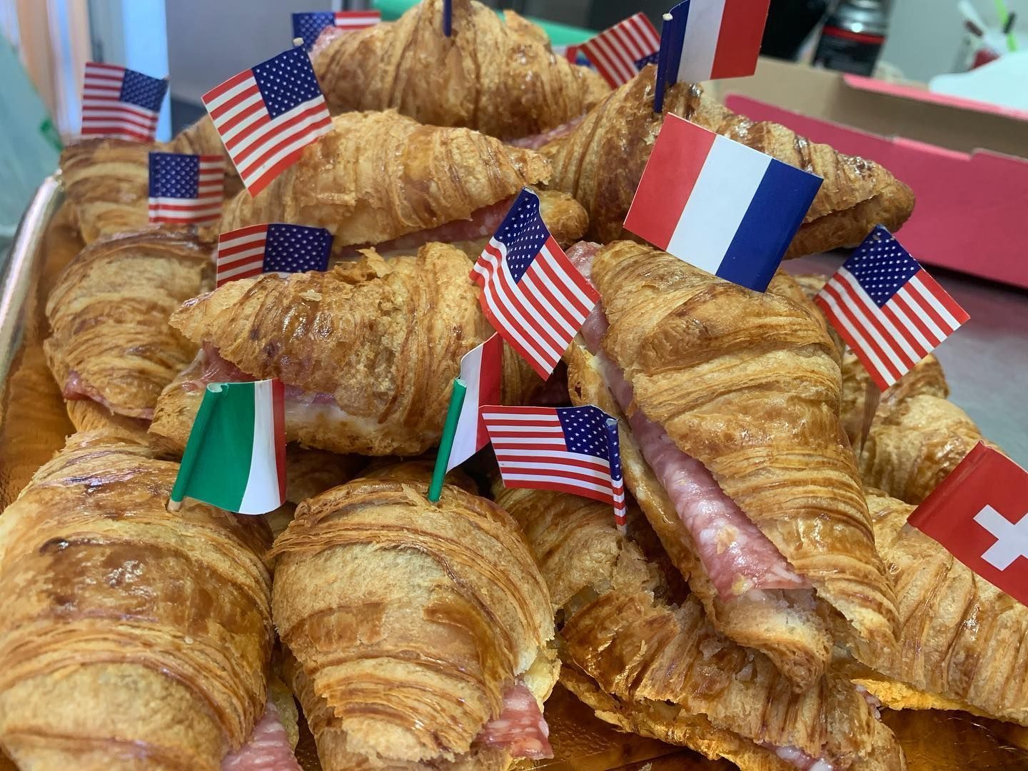 Un mucchio di croissant con sopra delle bandierine