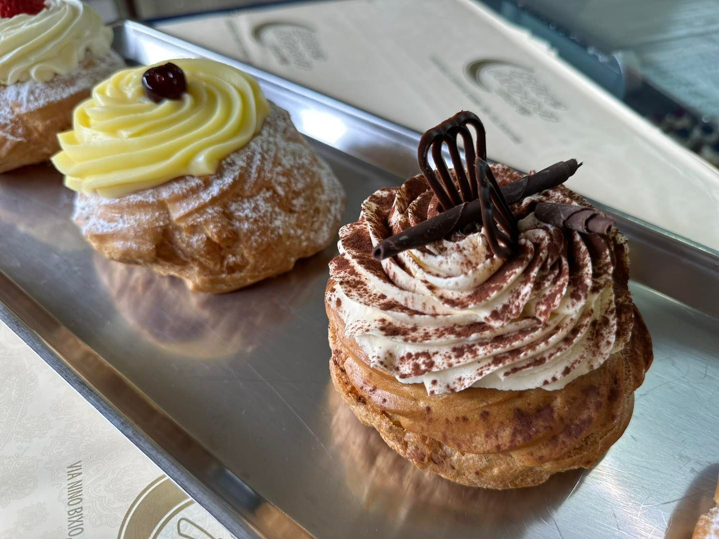 Tre pasticcini su un vassoio di cui uno è il tiramisù