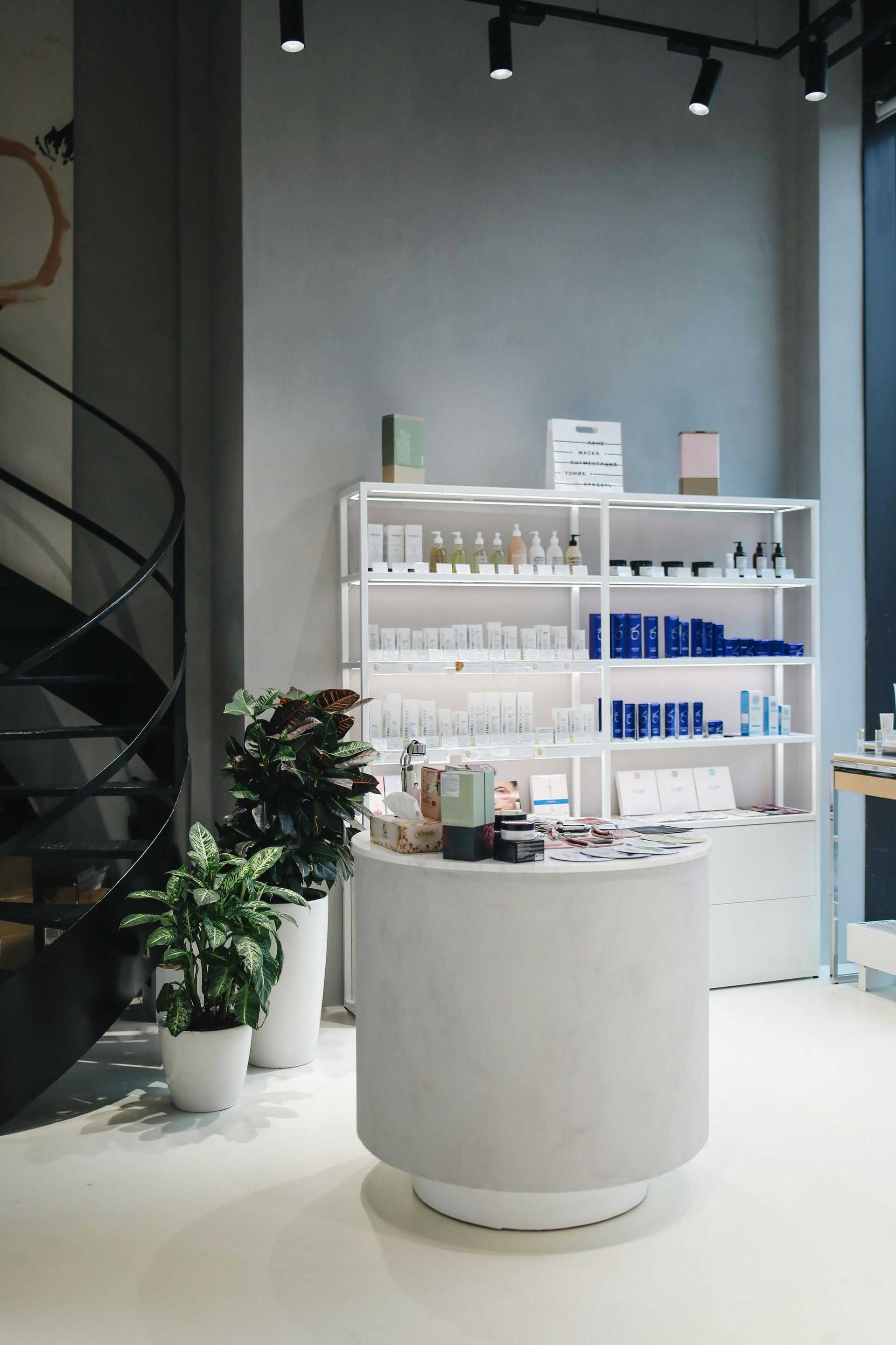 White minimalist skincare store with shelves, products, and a circular counter.