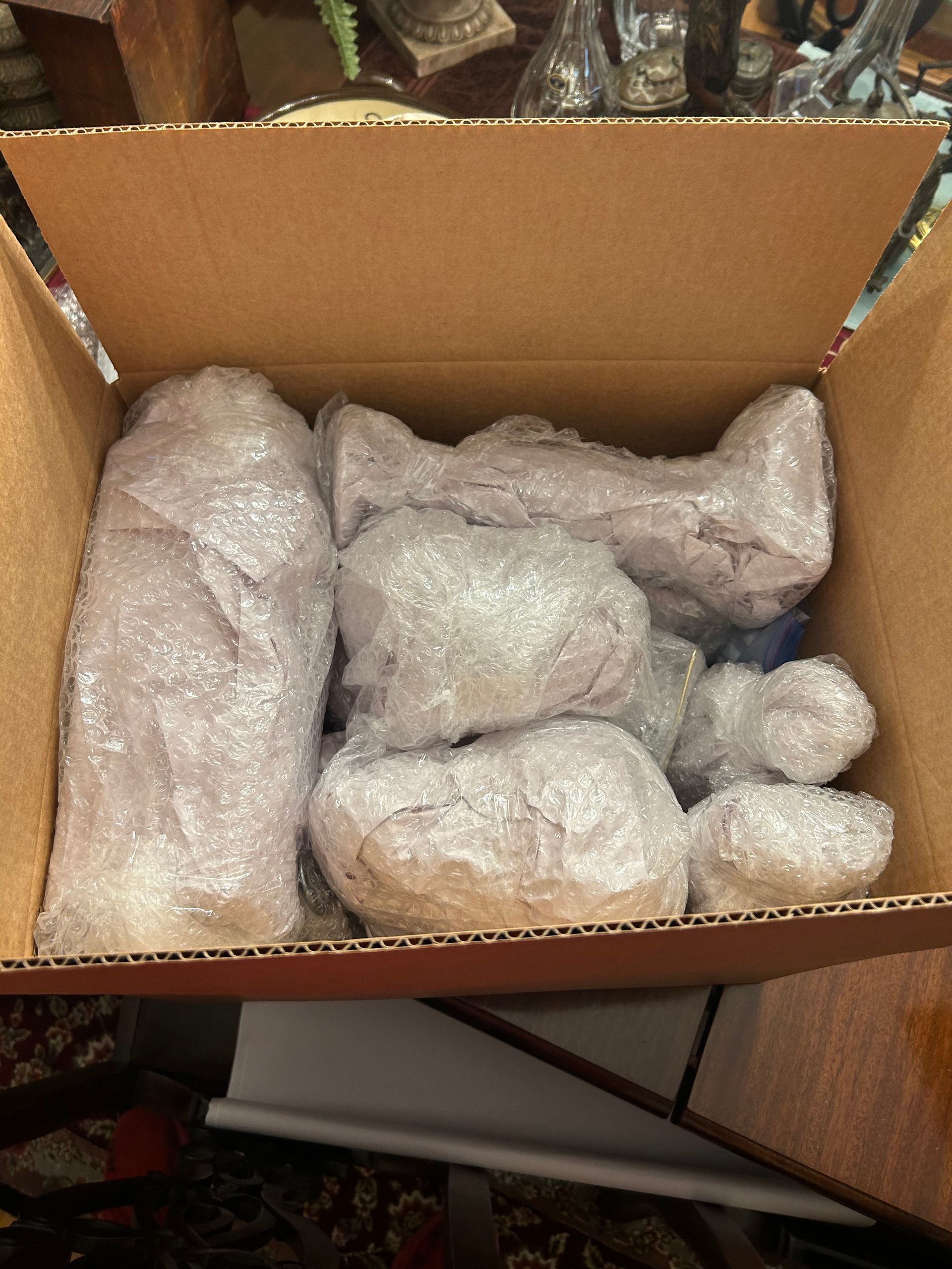 A cardboard box filled with bubble wrap and plastic wrap.